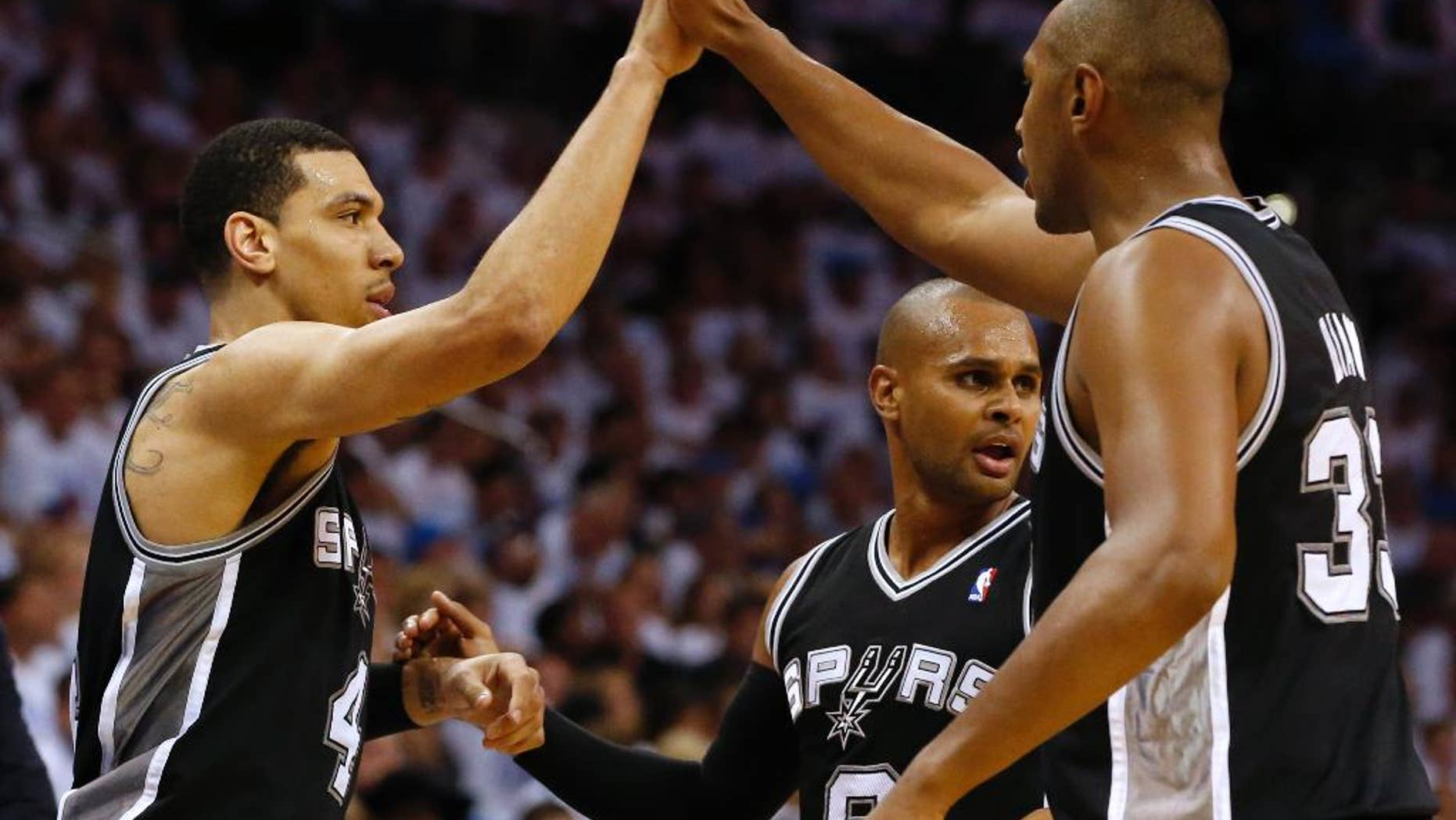 From left, San Antonio Spurs' Danny Green, Patty Mills, and Boris Diaw celebrate during the second half against the Oklahoma City Thunder in Game 6 of the Western Conference finals NBA basketball playoff series in Oklahoma City, Saturday, May 31, 2014. (AP Photo/Sue Ogrocki)