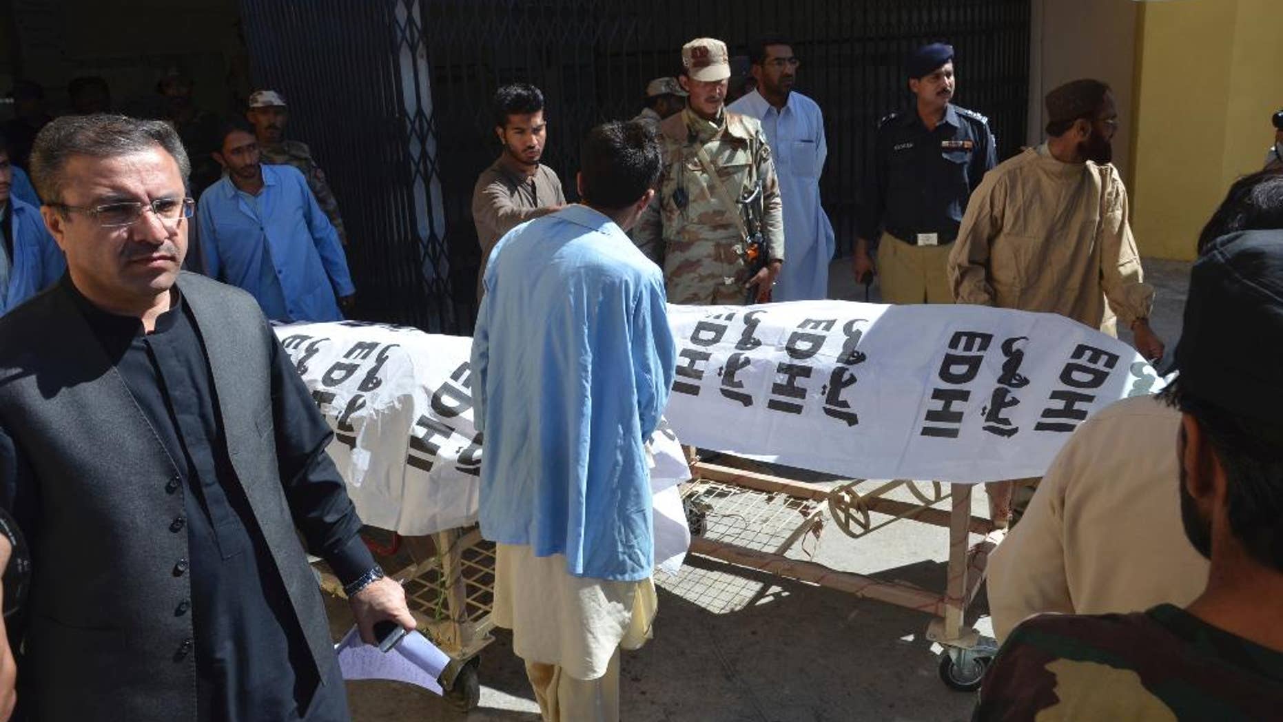 People carry dead bodies of paramilitary officers killed by gunmen in Quetta, Pakistan, Friday, Oct. 14, 20165. Gunmen riding on motorcycles shot and killed three paramilitary officers Friday in the southwestern Pakistani city of Quetta before fleeing, official said. The attack on FC guards, the Islamic State group claimed responsibility for the killing the three guards on street in Quetta, though there is no visible sign of IS in the city. (AP Photo/Arshad Butt)