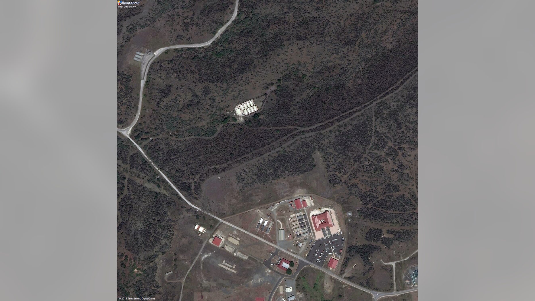 This satellite image provided by TerraServer.com and DigitalGlobe shows an image captured on Sept. 2, 2010, shows a portion of Naval Station Guantanamo Bay, Cuba, including the secret facility known as Penny Lane, upper middle in white. In the early years after 9/11, the CIA turned a handful of prisoners at the secret facility into double agents and released them. Current and former U.S. officials tell The Associated Press that the program helped kill terrorists. The program was carried out in the secret facility, built a few hundred yards from the administrative offices of the prison in Guantanamo Bay, bottom of image. The eight small cottages were hidden behind a ridge covered in thick scrub and cactus. (AP Photo/TerraServer.com and DigitalGlobe)