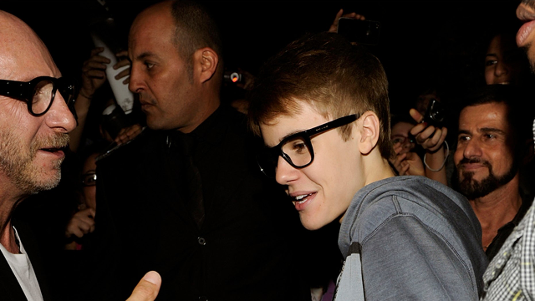 April 9, 2011: Canadian Pop singer Justin Bieber is welcomed by Domenico Dolce, left, as arrives at the Gold Restaurant after his concert in Milan , Italy