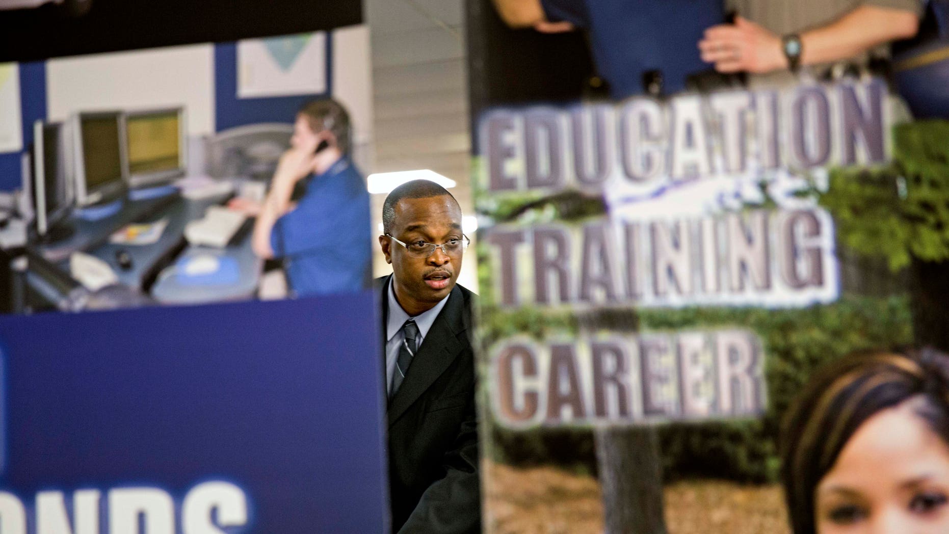 FILE - In this Thursday, Nov. 14, 2013, file photo, employment opportunity banners stand in the foreground as retired U.S. Navy Chief Jerome Porter, of Atlanta, talks with a recruiter during a job fair for veterans at the VFW Post 2681, in Marietta, Ga. The government reports on job openings and labor turnover for October, on Tuesday, Dec. 10, 2013. (AP Photo/David Goldman, File)