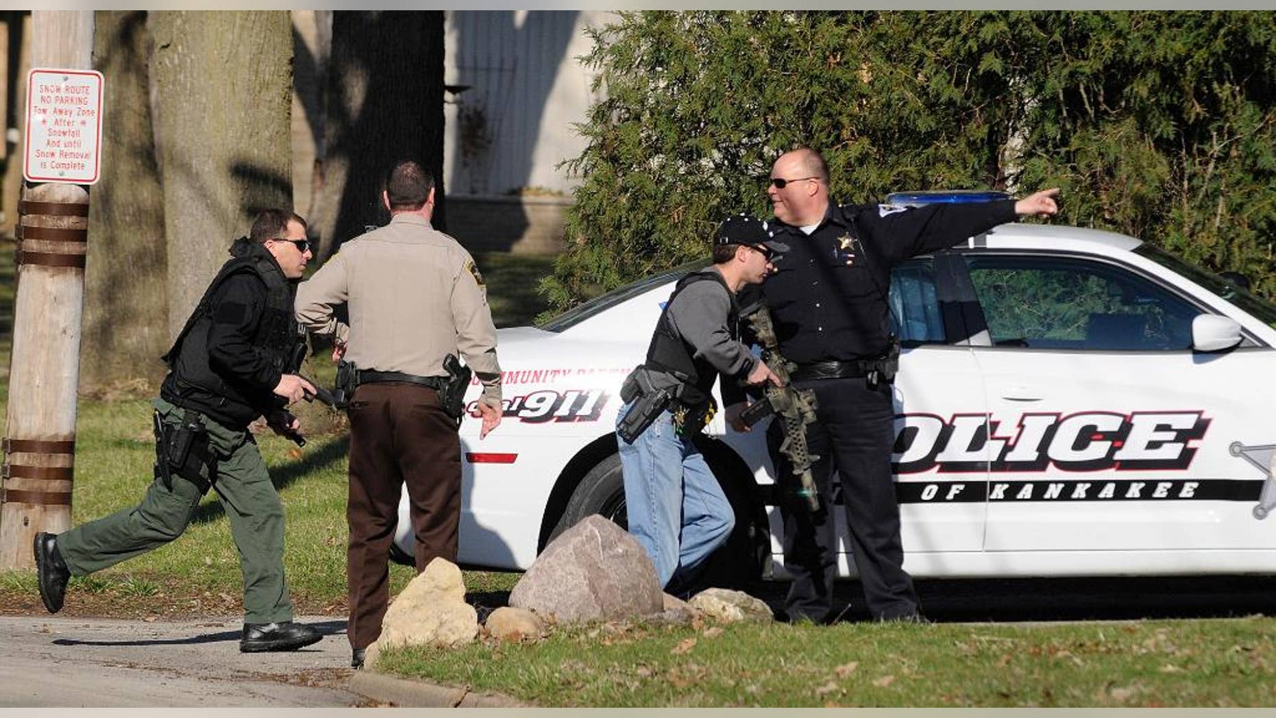 Police officers from the City of Kankakee and Kankakee County search for prison escapee Kamron T. Taylor in Kankakee, Ill., Wednesday, April 1, 2015. Authorities say Taylor, a convicted murderer who escaped from jail earlier in the day after beating a guard into unconsciousness, taking his keys and uniform and speeding off in his SUV. (AP Photo/The Daily Journal, Mike Voss)