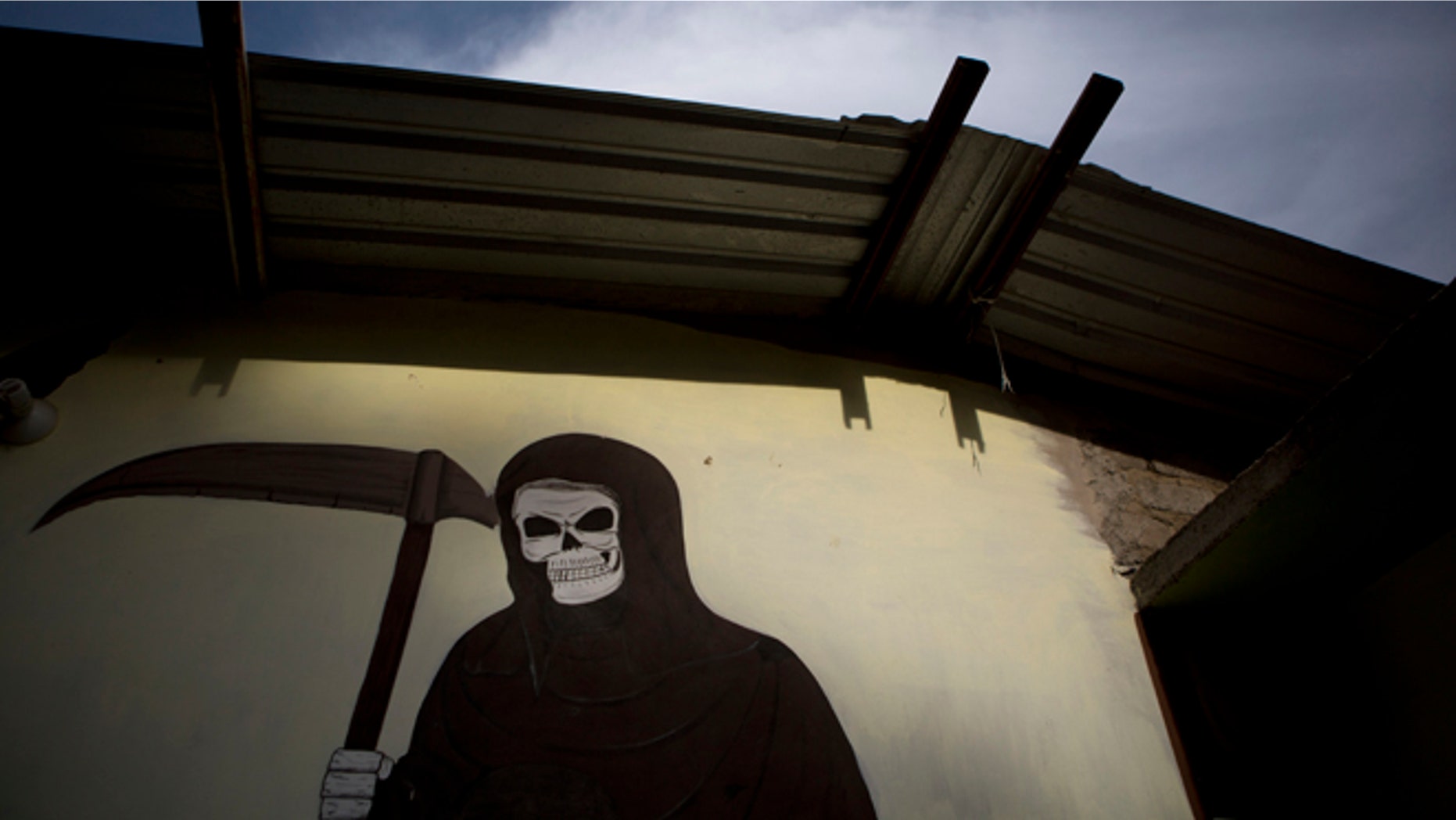 A mural of La Santa Muerte, or Saint Death, decorates the wall of a community center in Colonias, Michoacan state, Mexico, where vigilantes met with the families of a Tuesday shooting that took place in nearby Apatzingan, on Thursday, Jan. 8, 2015. Confrontations in Apatzingan began Tuesday when federal forces moved in to take control of city hall, which had been held for days by civilians whose demands and identities were unclear, according to Michoacan state Commissioner Alfredo Castillo. The second clash came when gunmen attacked soldiers who were transporting the seized vehicles to an impound lot, Castillo said. However, family members and witnesses tell a different story, one with a higher death toll. (AP Photo/Rebecca Blackwell)