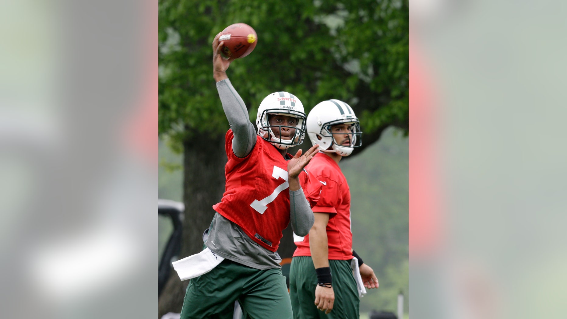 New York Jets' Geno Smith (7) throws a pass as Mark Sanchez (6) looks on as the quarterbacks practice during NFL football workouts in Florham Park, N.J., Wednesday, May 22, 2013. (AP Photo/Mel Evans)