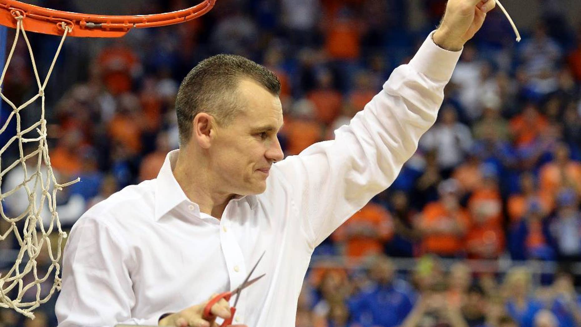 Florida coach Billy Donovan holds up a piece of the net after the Gators became the first team in Southeastern Conference history to go 18-0 in league pla, Saturday, March 8, 2014 in Gainesville, Fla. Florida defeated Kentucky 84-65 Saturday in an NCAA college basketball game. (AP Photo/Phil Sandlin)