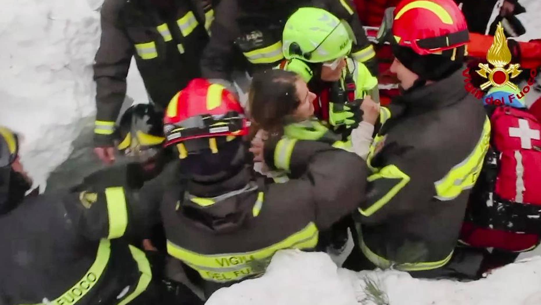 This frame from video shows Italian firefighters pulling out a woman from under the snow and debris.