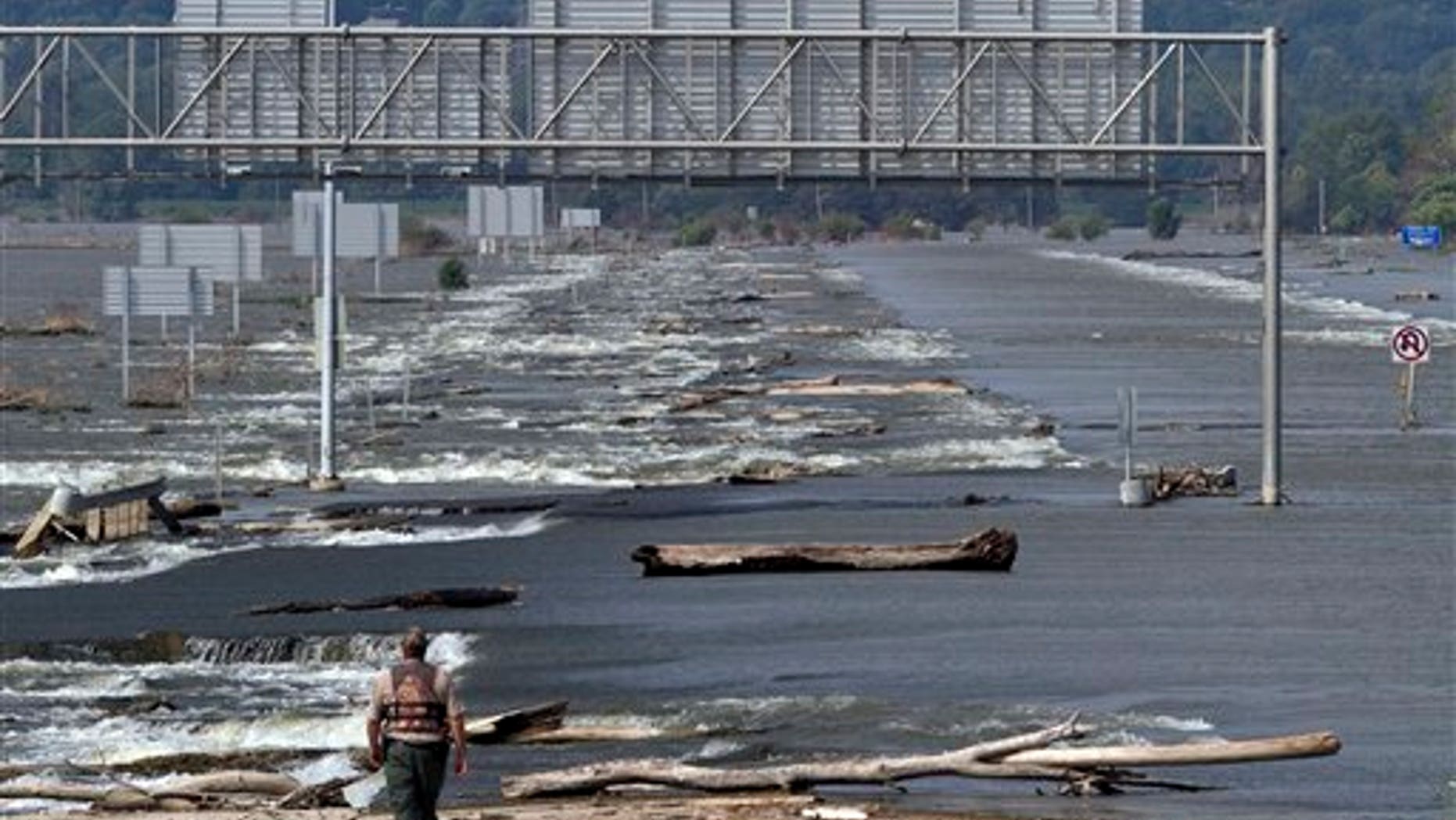 August 18: Mark Sedlmayr, conservation officer with the Iowa Department of Natural Resources, surveys damage and debris on Interstate 680 near Crescent, Iowa. The flooded fields of Crescent, Iowa, and Interstate 680, which is under water, can be seen from the Mormon Bridge over the Missouri River in Omaha, Neb.