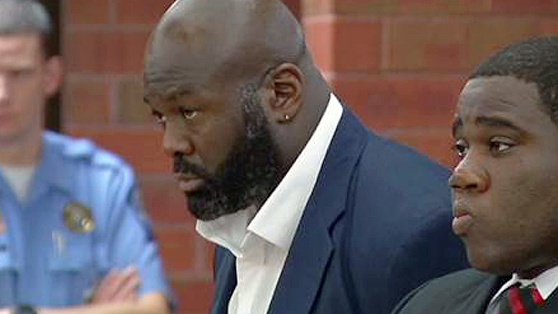 In this still image from video, former NFL defensive end Hugh Douglas, center, stands with his attorney, Corey Brinson, right, during arraignment in Superior Court on Monday, Oct. 21, 2013, in Hartford, Conn. Douglas, who played for the New York Jets, Philadelphia Eagles and Jacksonville Jaguars from 1995 to 2004, has pleaded not guilty to charges he assaulted his girlfriend at a Hartford hotel. (AP Photo/WFSB-TV, Peter McCue, Pool)