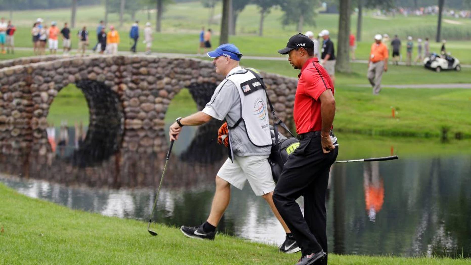 Tiger Woods and caddie Joe Lacava walk to the third green during the final round of the Bridgestone Invitational golf tournament Sunday, Aug. 3, 2014, at Firestone Country Club in Akron, Ohio. (AP Photo/Mark Duncan)