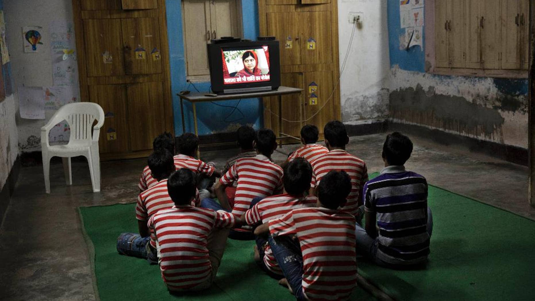 Children rescued by the workers of the NGO Bachpan Bachao Andolan or Save Childhood Movement, run by Kailash Satyarthi, watch the news of Pakistan’s Malala Yousafzai on television at the Mukti Ashram in New Delhi, India, Friday, Oct. 10, 2014. Satyarthi and Malala jointly won the Nobel Peace Prize on Friday for working to protect children from slavery, extremism and child labor at great risk to their own lives. (AP Photo/Bernat Armangue)