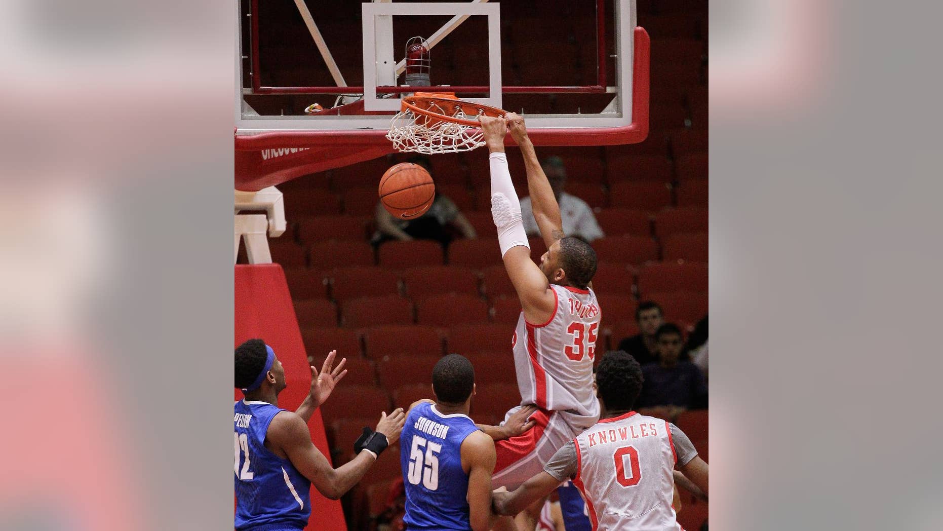 Houston's forward TaShawn Thomas (35) dunks on Memphis' Geron Johnson (55) during the first half of an NCAA college basketball game, Thursday, Feb. 27, 2014, in Houston. (AP Photo/Bob Levey)