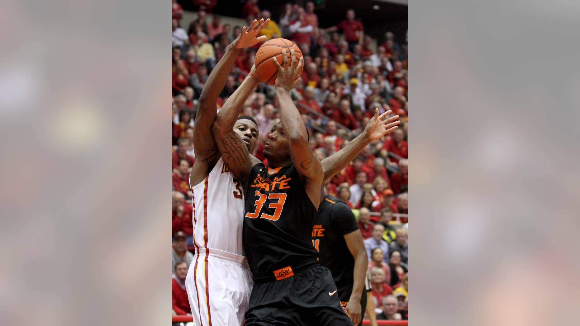 Oklahoma State guard Marcus Smart draws a foul on Iowa State forward Melvin Ejim as he drives to the basket during the second half of an NCAA college basketball game in Ames, Iowa, Saturday, March 8, 2014. Iowa State won 85-81 in overtime. (AP Photo/Justin Hayworth)