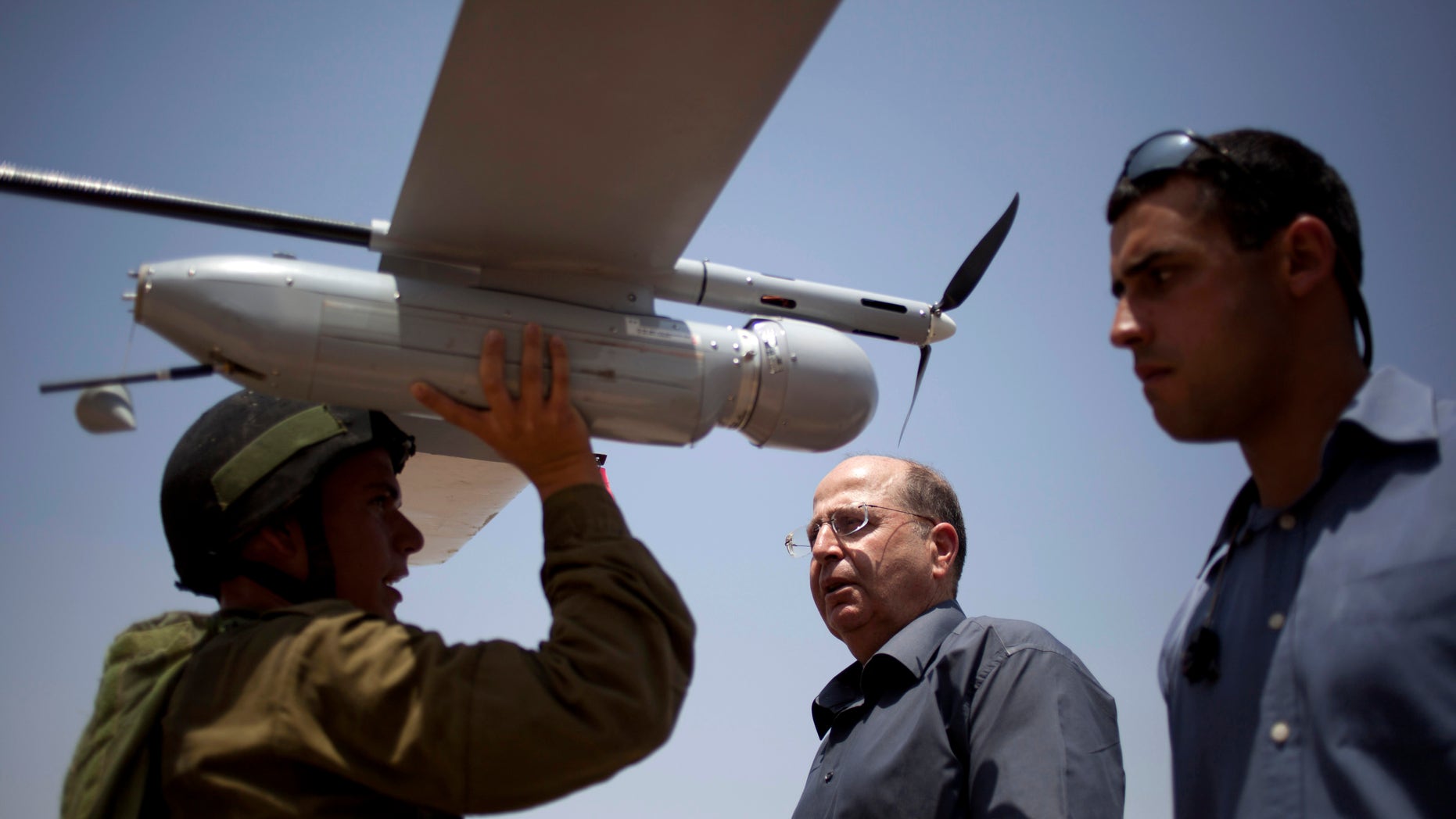 File - In this July 9, 2013 file photo, an Israeli soldier holds up a Skylark I (Rochev Shamayim) unmanned drone as part of a demonstration for Israel's Defense Minister Moshe Yaalon, center, in an urban warfare army training facility, near Zeelim, southern Israel. Israel’s defense minister was quoted Tuesday as deriding U.S. Secretary of State John Kerry’s Mideast peace efforts as naive and foolhardy, triggering an angry response from Washington and rekindling simmering tensions with Israel’s closest and most important ally. In the comments published by the Yediot Ahronot daily, Defense Minister Moshe Yaalon called Kerry “obsessive” and “messianic” and dismissed Kerry’s security plan as worthless. “The only thing that might save us is if John Kerry wins the Nobel Prize and leaves us be,” Yaalon was quoted as saying in private conversations. (AP Photo/Ariel Schalit, File)