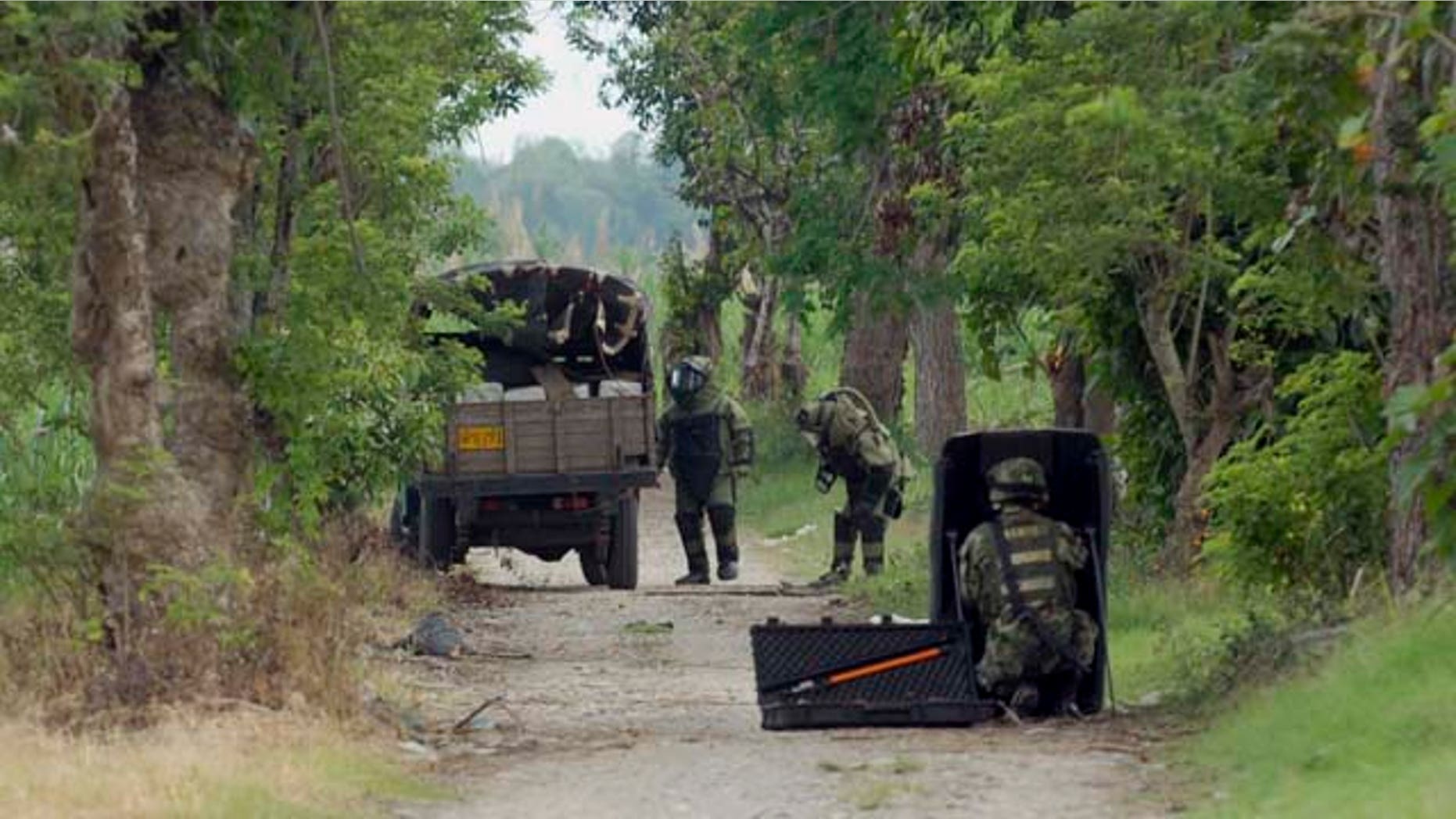 Members of a police bomb squad inspect a truck believed to be loaded with explosives in Corinto, southern Colombia, Tuesday June 21, 2011. The officers did not find explosives in the vehicle, instead they found one ton of marijuana. Rebels of the Revolutionary Armed Forces of Colombia, FARC, and the National Liberation Army, ELN, are active in the region. (AP Photo/Carlos Julio Martinez)