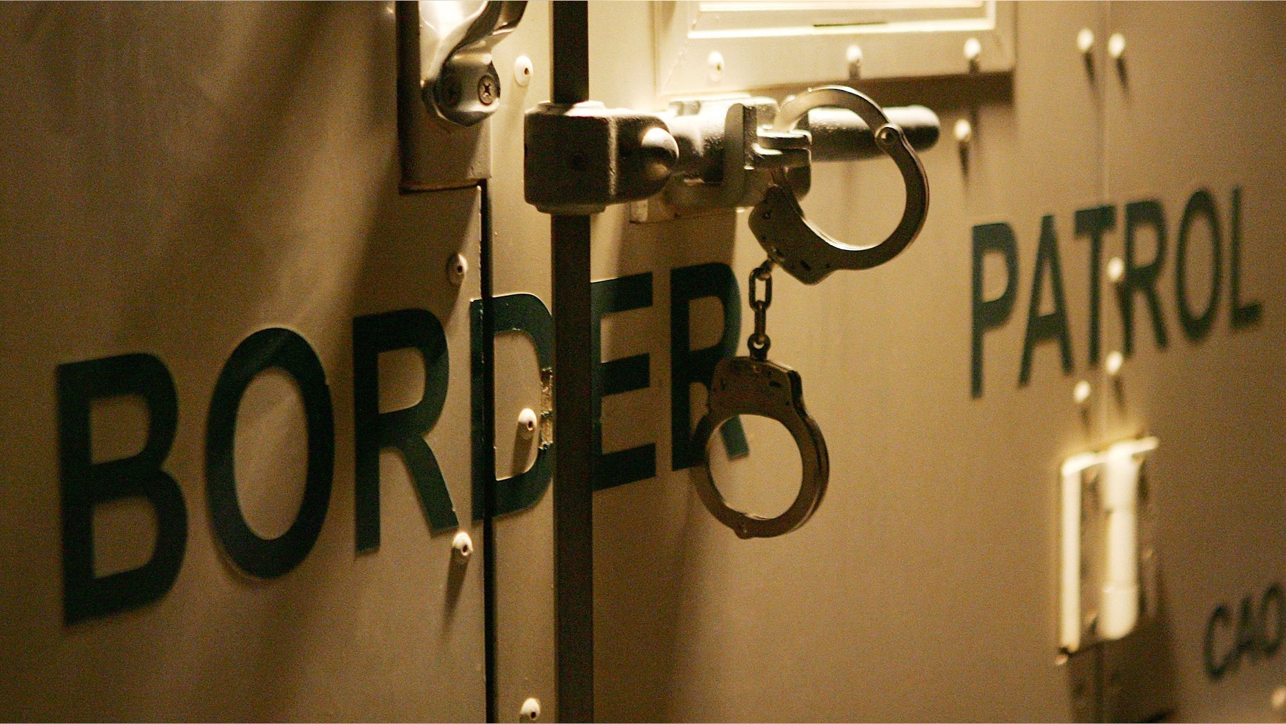 YUMA, AZ - MARCH 17: Handcuffs secure the back door of a US Customs and Border Protection border patrol vehicle loaded with suspected illegal immigrants on the California side of the Colorado River on March 17, 2006 near Yuma, Arizona. As Congress begins a new battle over immigration policy, U.S. Customs and Border Protection (CBP) border patrol agents in Arizona are struggling to control undocumented immigrants that were pushed into the region by the 1990?s border crack-down in California called Operation Gatekeeper. A recent study by the Pew Hispanic Center using Census Bureau data estimates that the U.S. currently has an illegal immigrant population of 11.5 million to 12 million, about one-third of them arriving within the past 10 years. More than half are from Mexico. Beefed-up border patrols and increased security are reportedly having the unintended result of deterring many from returning to their country of origin. (Photo by David McNew/Getty Images)
