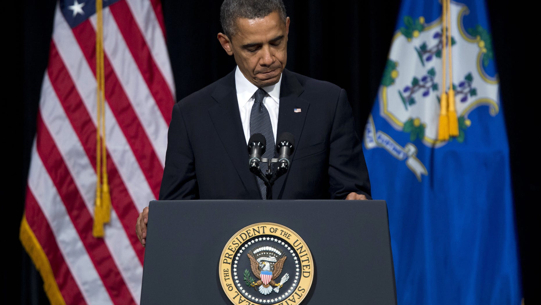 President Barack Obama pauses during a speech at an interfaith vigil for the victims of the Sandy Hook Elementary School shooting on Sunday, Dec. 16, 2012 at Newtown High School in Newtown, Conn. A gunman walked into Sandy Hook Elementary School on Friday and opened fire, killing 26 people, including 20 children. (AP Photo/Evan Vucci)