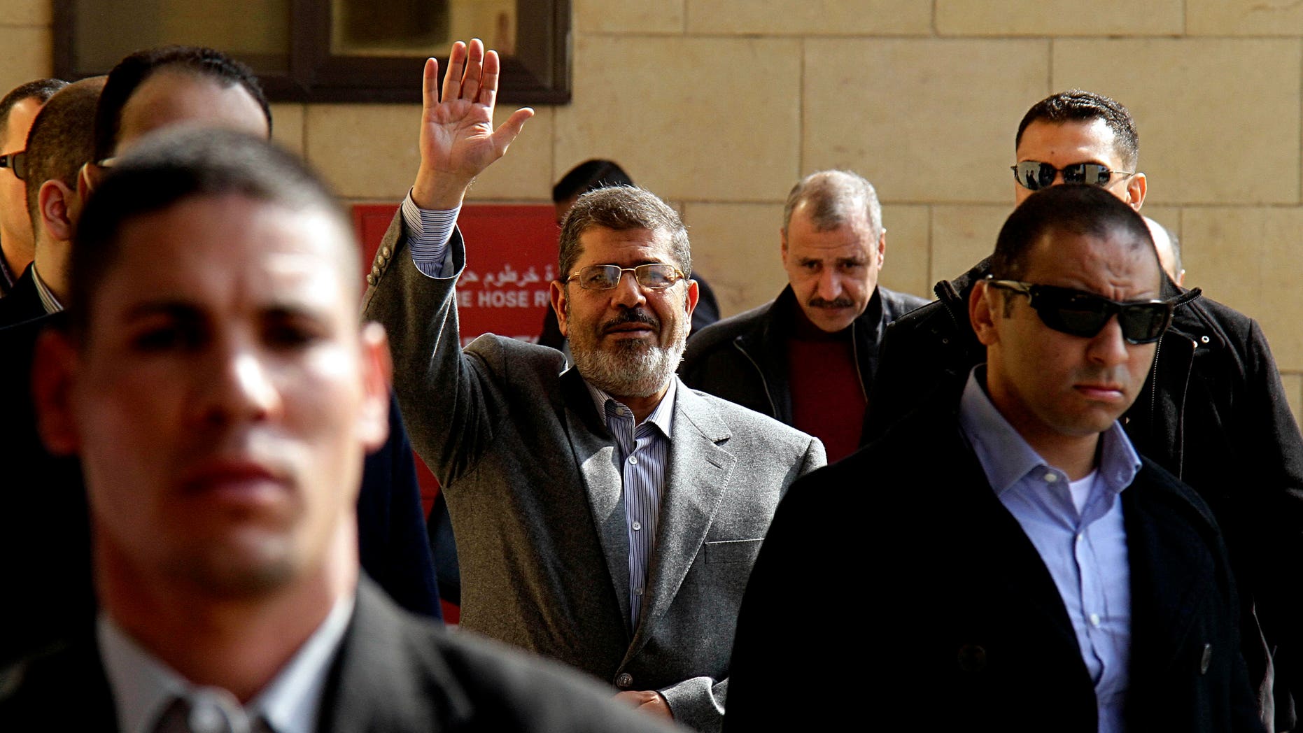 In this Friday, Jan. 4, 2013 file photo, Egyptian President Mohammed Morsi, center, waves to supporters after attending Friday prayers at the Hassan Sharbatli mosque on the outskirts of Cairo, Egypt. Morsi, in a rambling 2.15-hour TV interview that aired in the early hours of Feb, 25, 2013, dismissed the masses protesting against his rule across much of the nation as "thugs" and "outlaws."