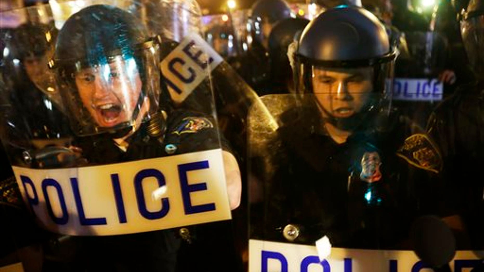 Police in riot gear push back on media and a crowd gathering in the street after a 10 p.m. curfew went into effect Thursday, April 30, 2015, in Baltimore. The curfew was imposed after unrest in the city over the death of Freddie Gray while in police custody. (AP Photo/David Goldman)