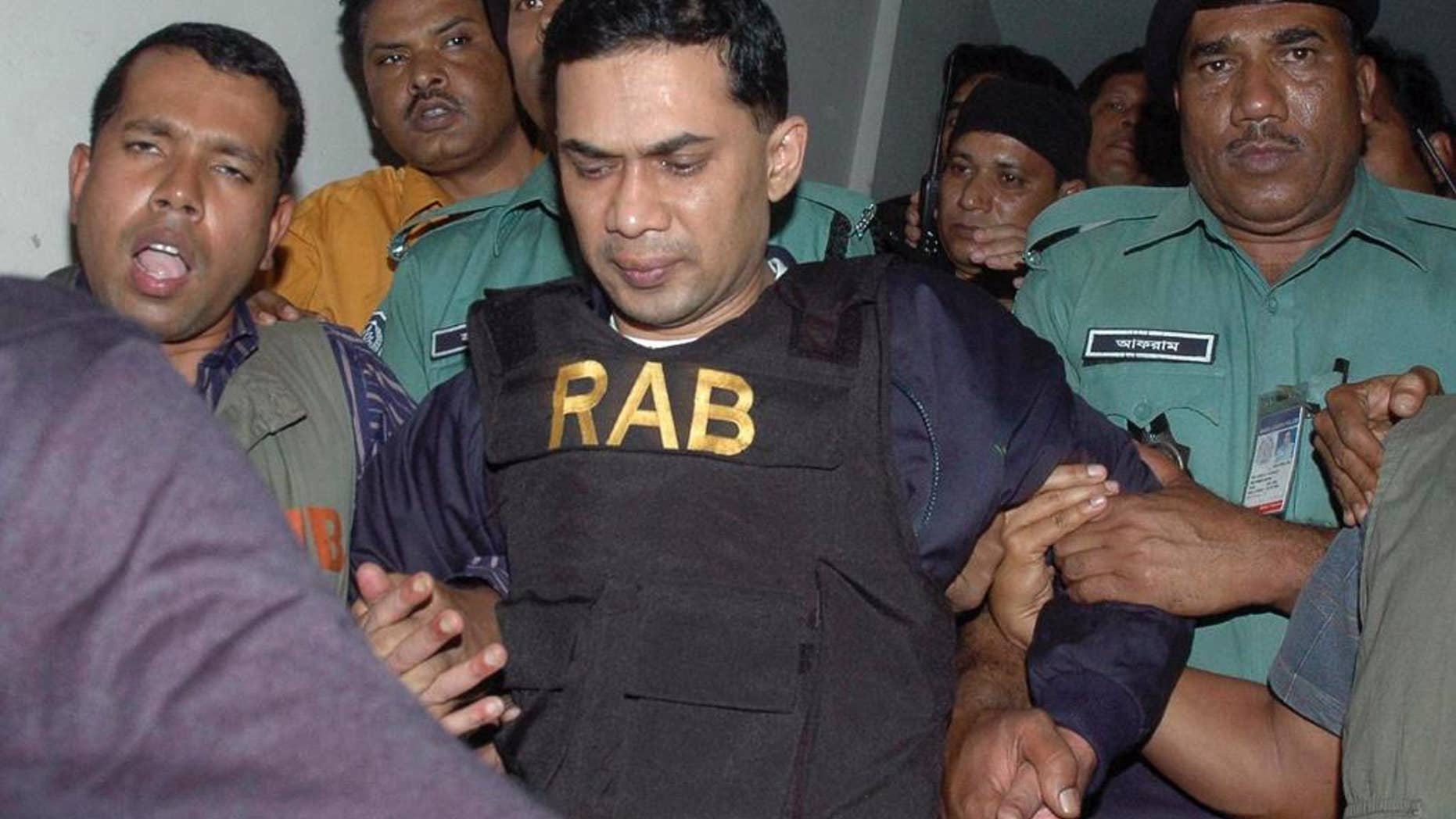 FILE - In this March 8, 2007 file photo, Tarique Rahman, center, who was charged with receiving bribes, is escorted by Bangladeshi security personnel to a court in Dhaka, Bangladesh. Bangladesh's High Court on Thursday, July 21, 2016 sentenced Rahman the son of the country's top opposition leader Khaleda Zia to seven years in jail in a money laundering case, overturning an acquittal handed down by a lower court. (AP Photo/Indrajit Kumer Ghosh, File)