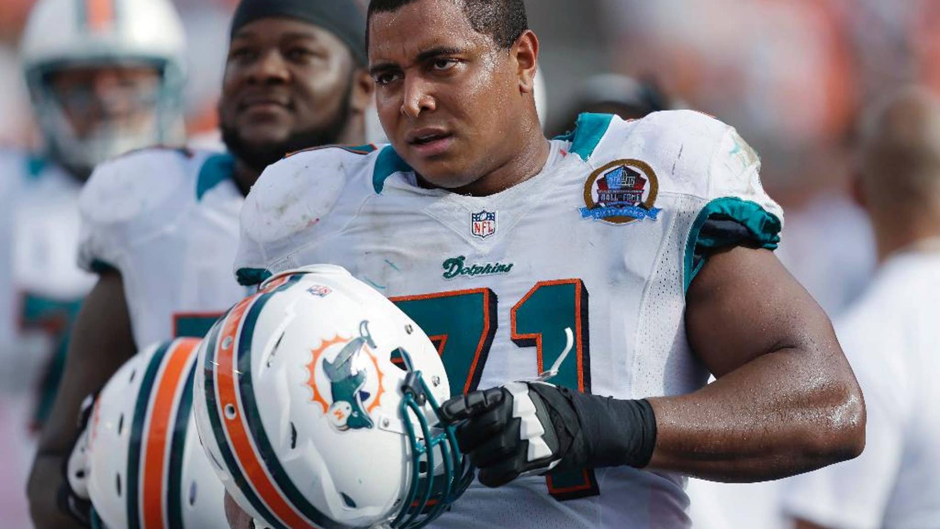 In this Dc. 16, 2012, photo, Miami Dolphins tackle Jonathan Martin (71) stands on the sidelines during the Dolphins' NFL football game against the Jacksonville Jaguars in Miami. Martin, the offensive tackle at the center of the Dolphins' bullying scandal, has been traded to the San Francisco 49ers. The Dolphins announced the deal Tuesday night, March 11, 2014, on the first day of NFL free agency. Martin's move cross country brings him back to the Bay Area to be reunited with his former Stanford coach, Jim Harbaugh. (AP Photo/Wilfredo Lee)