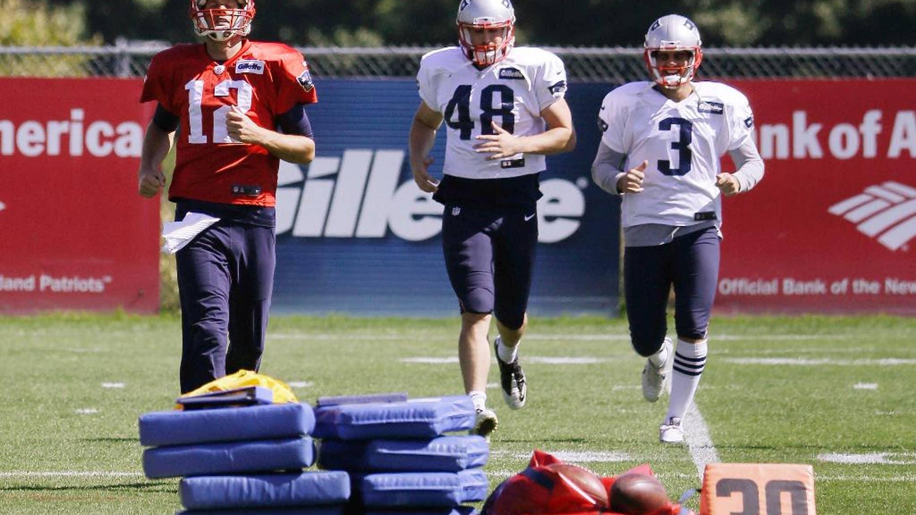 New England Patriots quarterback Tom Brady (12), long snapper Danny Aiken (48) and kicker Stephen Gostkowski (3) run during a stretching session before practice begins at the NFL football team's facility Wednesday, Sept. 17, 2014 in Foxborough, Mass. (AP Photo/Stephan Savoia)