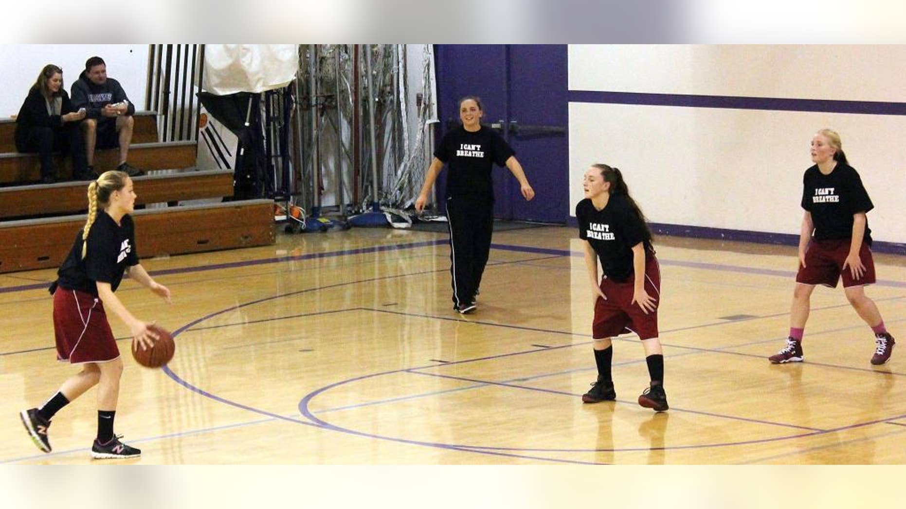 This photo provided by the Fort Bragg Advocate-News shows Mendocino High School girls basketball wearing the "I Can't Breathe" T-shirts before a recent game. A high school basketball tournament on the Northern California coast has become the latest flashpoint in the ongoing protests over police killings of unarmed black men after a school was disinvited because of concerns its players would wear T-shirts printed with the words "I Can't Breathe" during warmups. The athletic director at Fort Bragg High School informed his counterpart at Mendocino High School this week that neither the boys nor girls team would be allowed to participate in the three-day tournament hosted by Fort Bragg High starting Monday, Mendocino Unified School District Superintendent Jason Morse said. (AP Photo/Fort Bragg Advocate-News, Chris Calder)