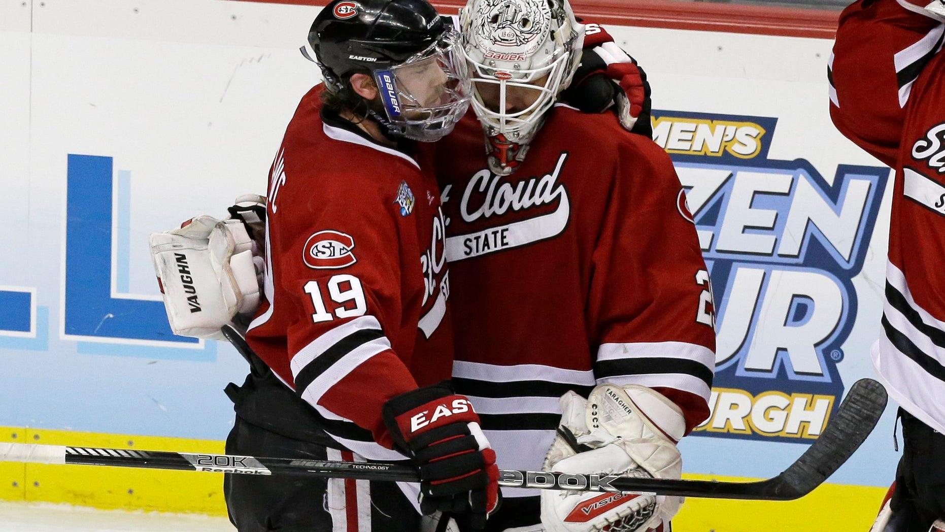 St. Cloud State goalie Ryan Faragher, right, is hugged by Drew LeBlanc (19) after losing 4-1 to Quinnipiac in an NCAA college hockey Frozen Four semifinal game in Pittsburgh, Thursday, April 11, 2013. Quinnipiac faces Yale in the national championship game on Saturday. (AP Photo/Gene J. Puskar)