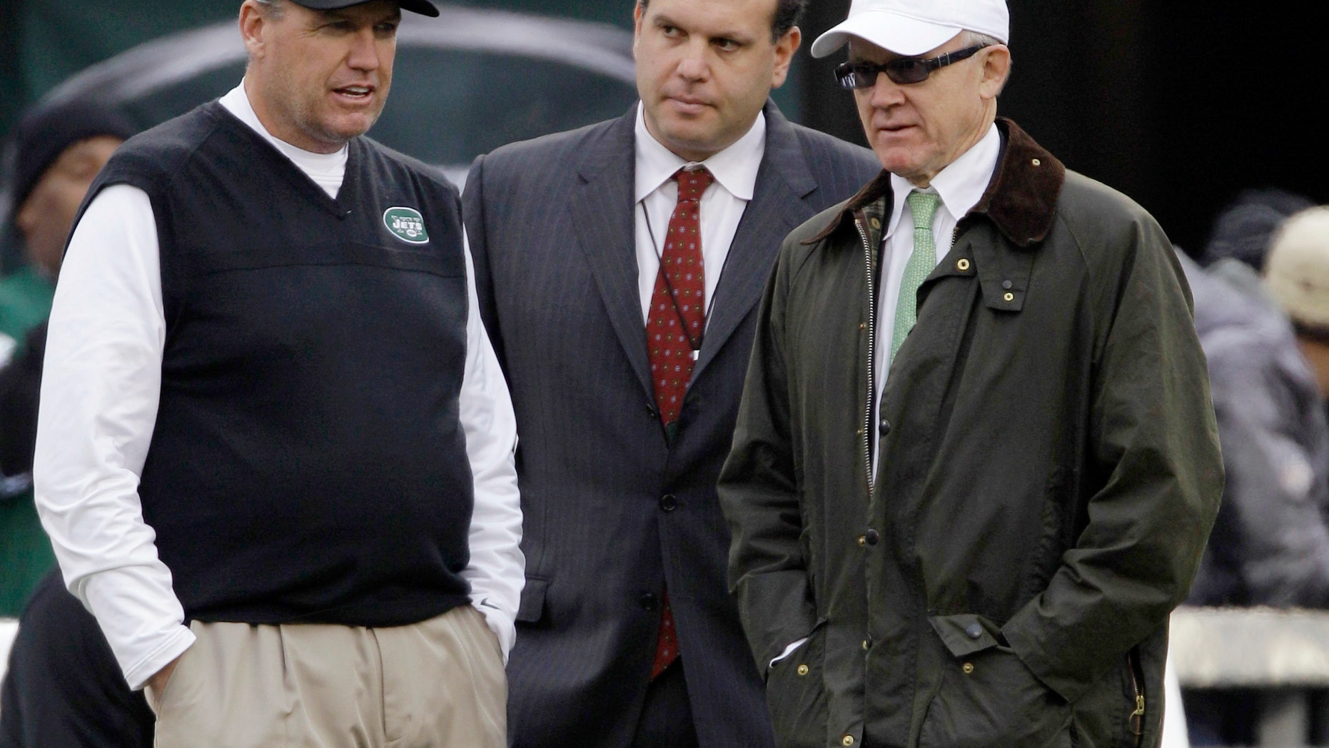 FILE - In this Dec. 2, 2012, file photo, New York Jets head coach Rex Ryan, left, stands with general manager Mike Tannenbaum, center, and owner Woody Johnson before an NFL football game against the Arizona Cardinals in East Rutherford, N.J. Ryan insists he's a Jet all the way and wants to coach the team for the "next 15 years." He dismisses as "untrue" a report that says he would welcome being fired if Johnson doesn't upgrade the offense. (AP Photo/Kathy Willens, File)