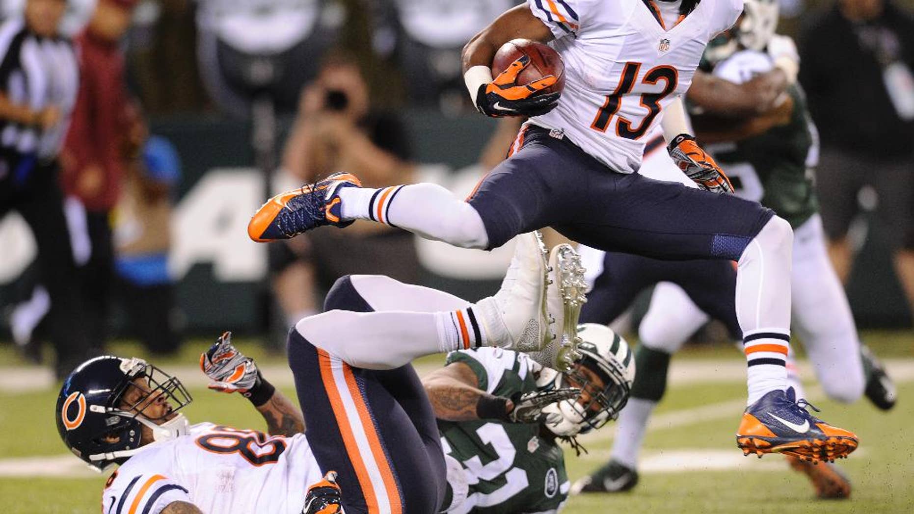 Chicago Bears wide receiver Rashad Ross (13) leaps over teammate tight end Dante Rosario (88) and New York Jets defensive back Ellis Lankster (31) in the first quarter of an NFL football game, Monday, Sept. 22, 2014, in East Rutherford, N.J. (AP Photo/Bill Kostroun)
