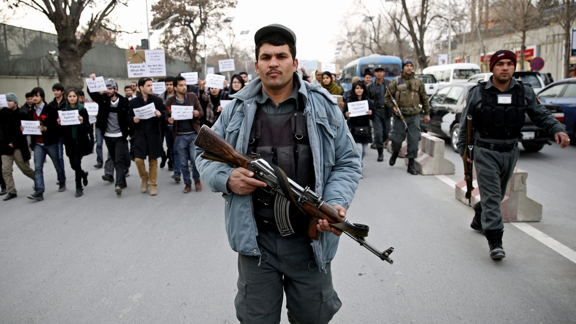 Jan. 19, 2014: An Afghan police walks ahead of members of civil society organizations for their protection as they march in a street, during an anti-terrorism demonstration in Kabul, Afghanistan.
