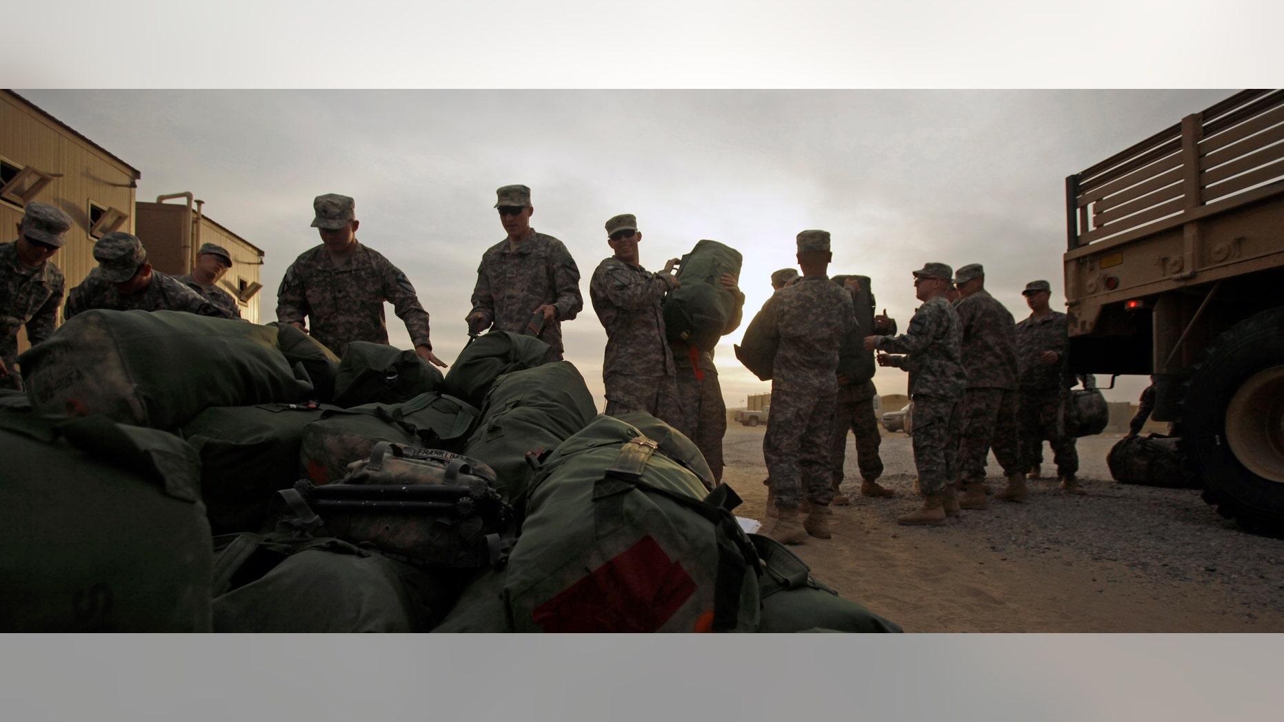 U.S. Army soldiers from 1st Cavalry Division, based at Fort Hood, Texas, load their baggage as they begin their journey home after a deployment in Iraq, at Camp Virginia, Kuwait, Thursday, Dec. 15, 2011. After nearly nine years, 4,500 American dead and 100,000 Iraqi dead, U.S. officials formally shut down the war in Iraq - a conflict that Defense Secretary Leon Panetta said was worth the American sacrifice because it set Iraq on a path to democracy. (AP Photo/Maya Alleruzzo)