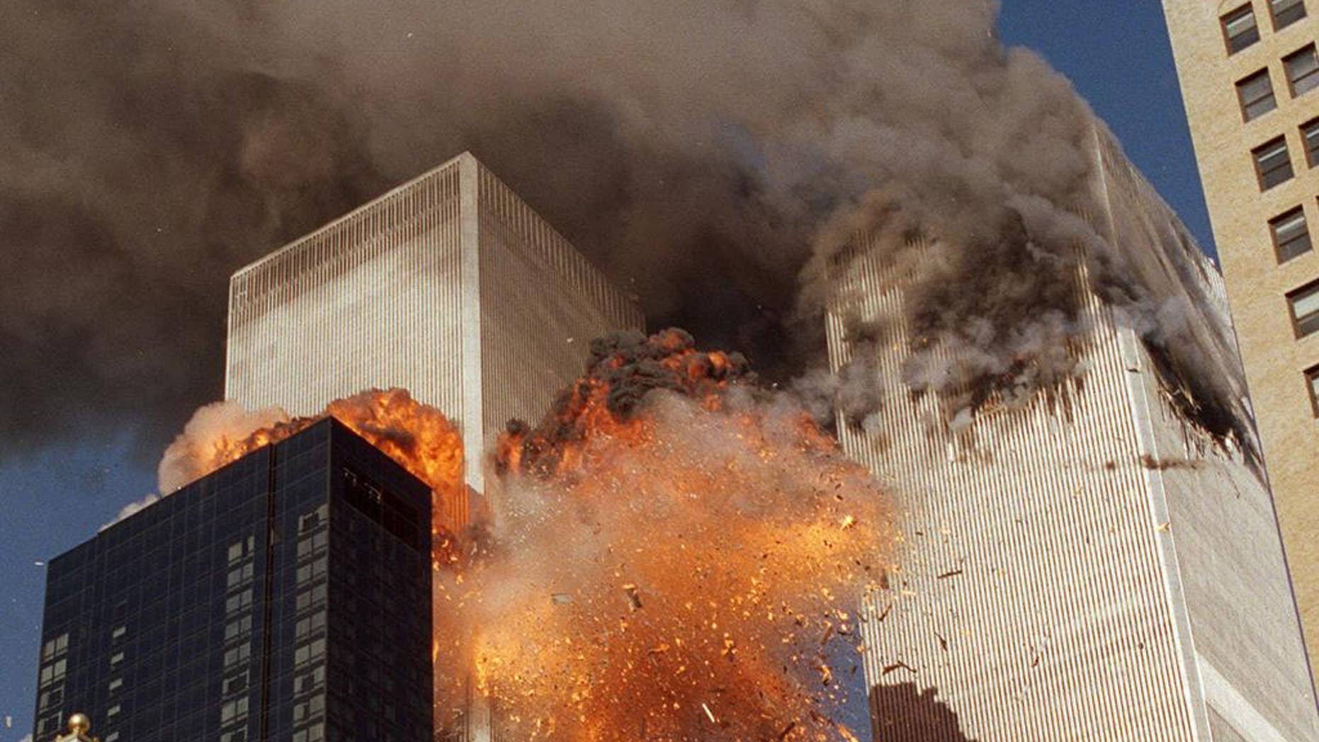 FILE - In this Sept. 11, 2001, file photo, smoke billows from one of the towers of the World Trade Center and flames as debris explodes from the second tower in New York. Family members of 9/11 families and others harmed in the terrorist attacks are on a fresh quest to hold Saudi Arabia responsible. A magistrate judge presiding over a Thursday, March 23, 2017, hearing says she hopes to streamline the legal process to speed the lawsuits along. (AP Photo/Chao Soi Cheong, File)