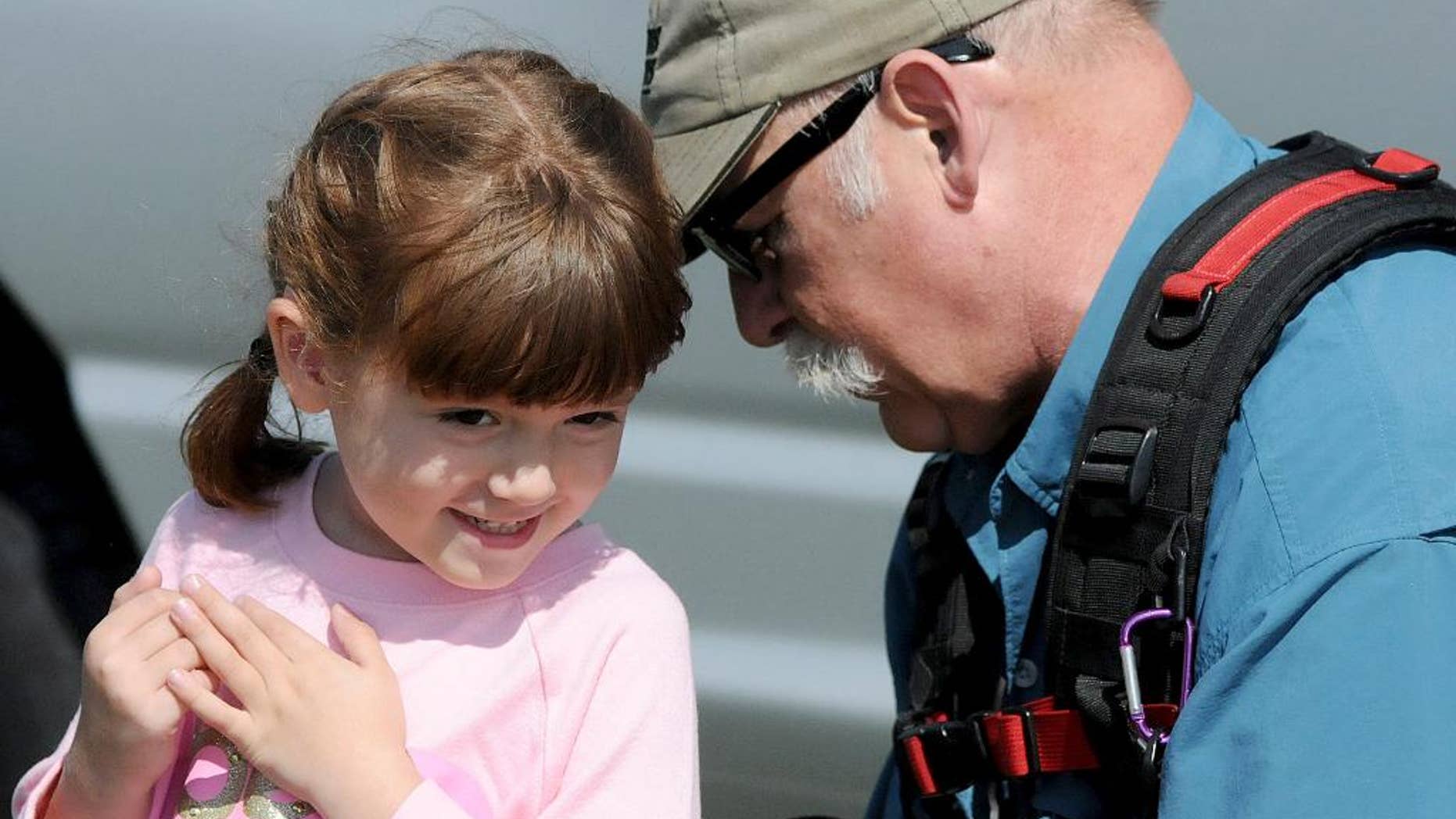 This Friday, Sept. 19, 2015 photo shows Elizabeth "Lizzy" Myers, left, being fitted for a microphone by a CBS sound man before taping a segment in Lucas, Ohio. Myers, a 5-year-old Ohio girl whose parents created a "visual bucket list" for her because she's slowly going blind is going to meet Pope Francis. Steve Myers told the Mansfield News Journal on Thursday, March 24, 2016, that his daughter Elizabeth "Lizzy" Myers is visiting the Vatican next week. (Jason J. Molyet/News Journal via AP) NO SALES; MANDATORY CREDIT