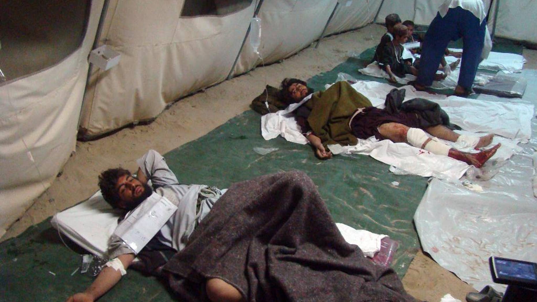 Wounded Afghani men and children lie on the ground in a tent after a deadly attack targeted a checkpoint, in Lashkar Gah, capital of the southern Helmand province, Afghanistan, Tuesday, March 10, 2015. A series of bombings across Afghanistan killed at least 13 people and wounded dozens Tuesday, authorities said. Afghanistan's army has been fighting to clear large parts of Helmand of Taliban militants. (AP Photo/Abdul Khaliq)