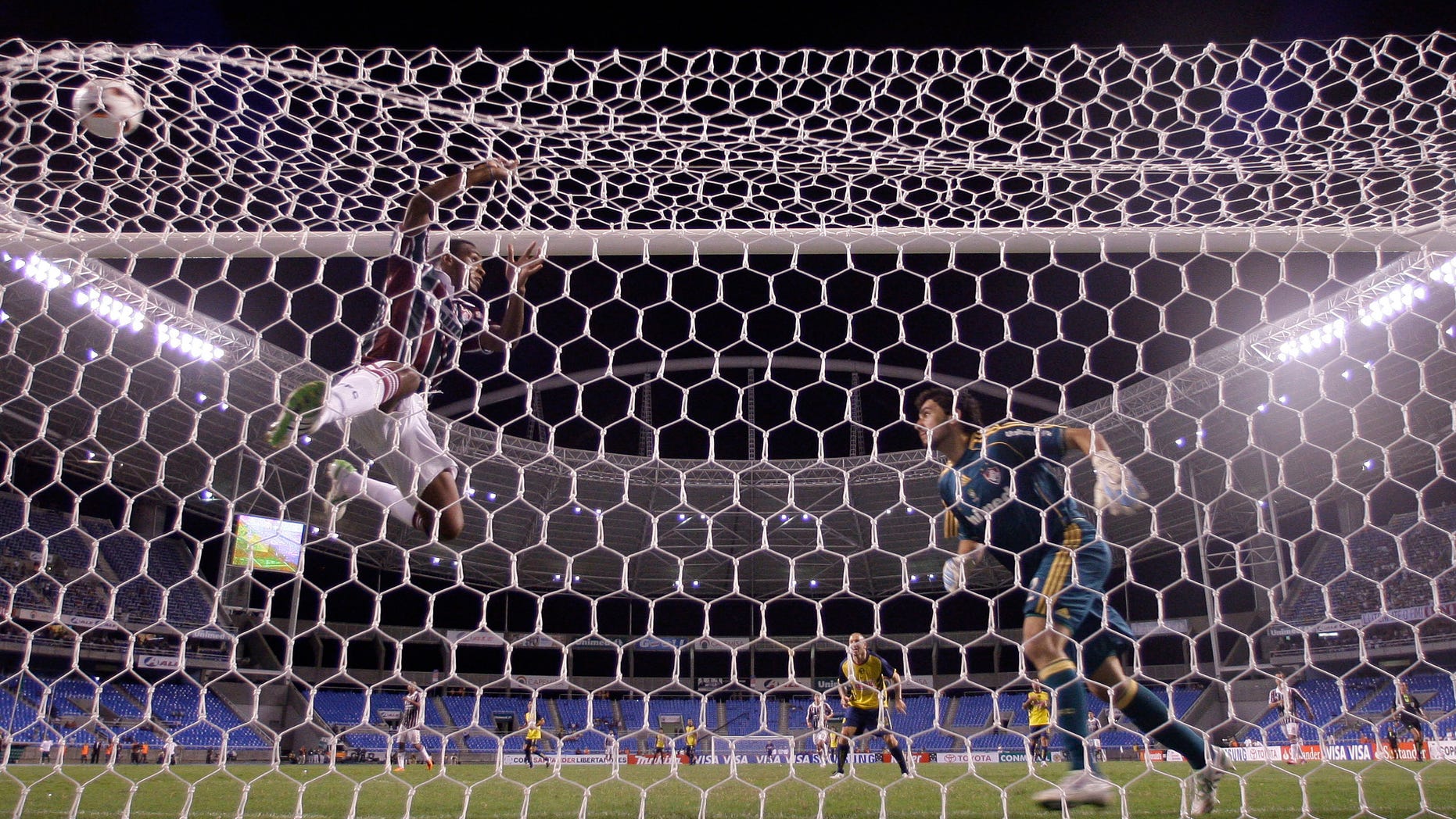 Brazil's Fluminense goalkeeper Ricardo Berna, right, and Digao, left, fail to stop a goal by Vicente Sanchez of Mexico's CF America during a Copa Libertadores soccer match in Rio de Janeiro, Brazil, Wednesday, March 23, 2011. Brazil's Fluminense won the match 3-2. (AP Photo/Felipe Dana)
