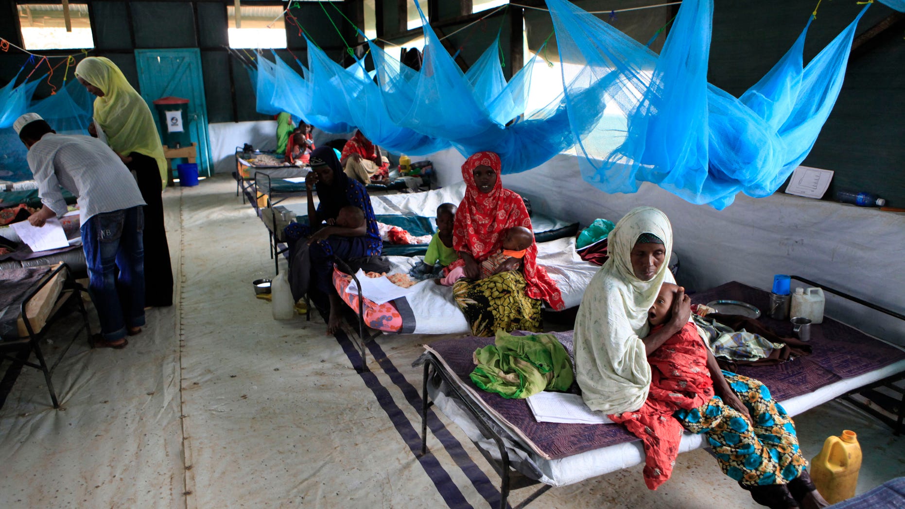 July 11, 201: Somali parents care for their young children who are being treated for malnutrition at a Doctors Without Borders (Medecins Sans Frontieres) hospital in Dagahaley Camp, Dadaab, Kenya.