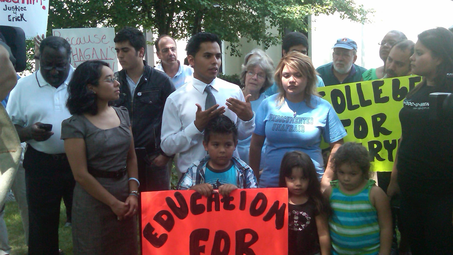Erick Velazquillo, center wearing a tie, responds to a decision following a Charlotte, N.C., deportation hearing.