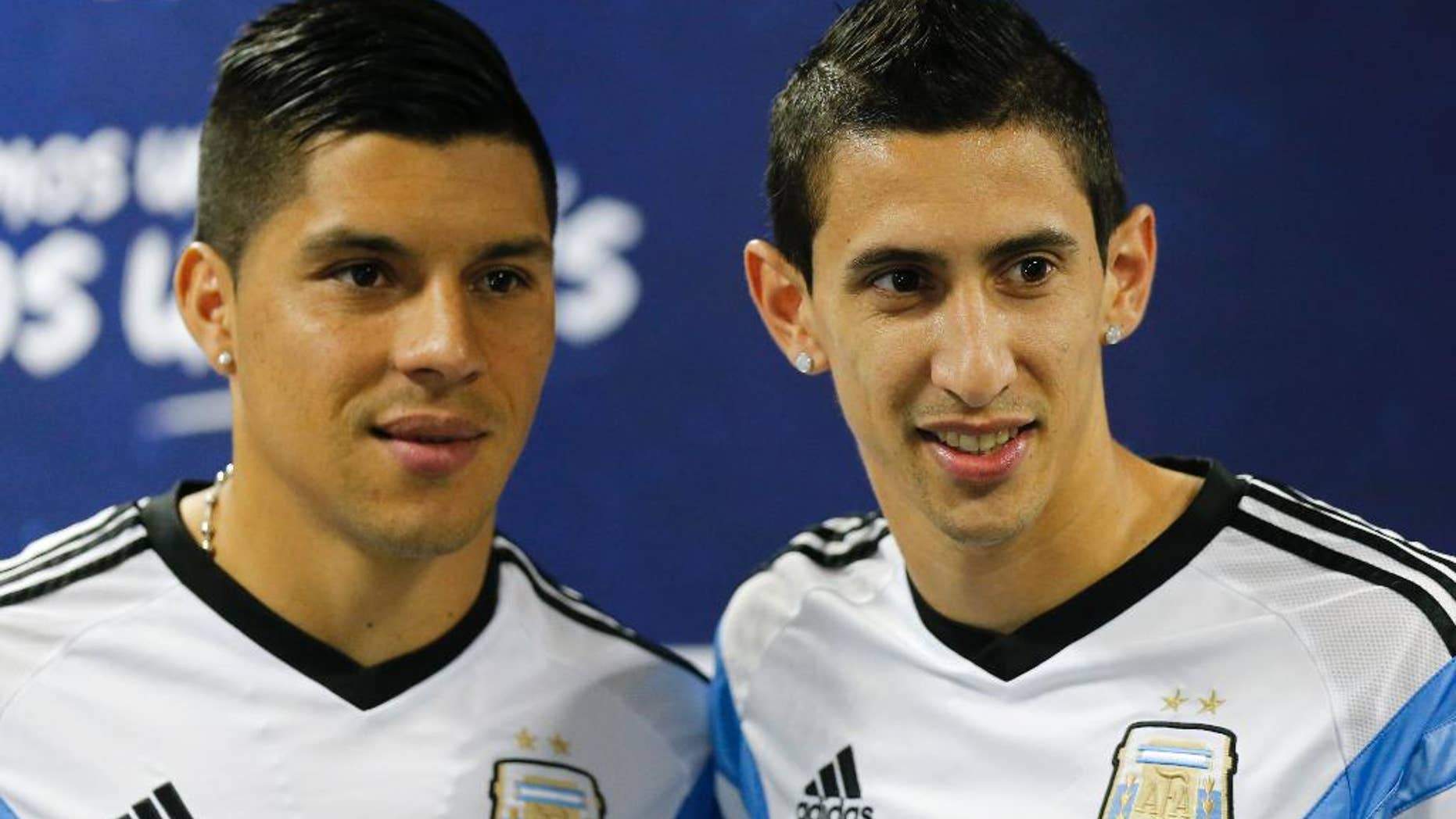 Argentina's Angel di Maria, right, and teammate Enzo Perez pose for photographers at the start of a news conference in Vespesiano, near Belo Horizonte, Brazil, Sunday, June 22, 2014. Argentina plays in group F of the 2014 soccer World Cup. (AP Photo/Victor R. Caivano)