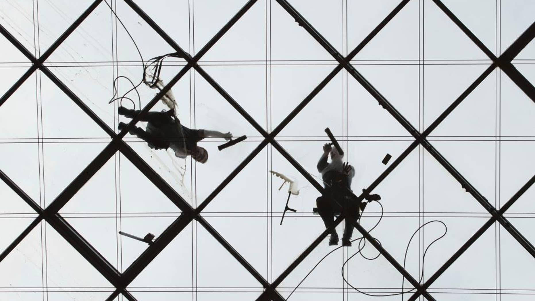 Two workers clean the glass roof of the World Trade Center in Dresden, eastern Germany, Monday, April 3, 2017. (Sebastian Kahnert/dpa via AP)
