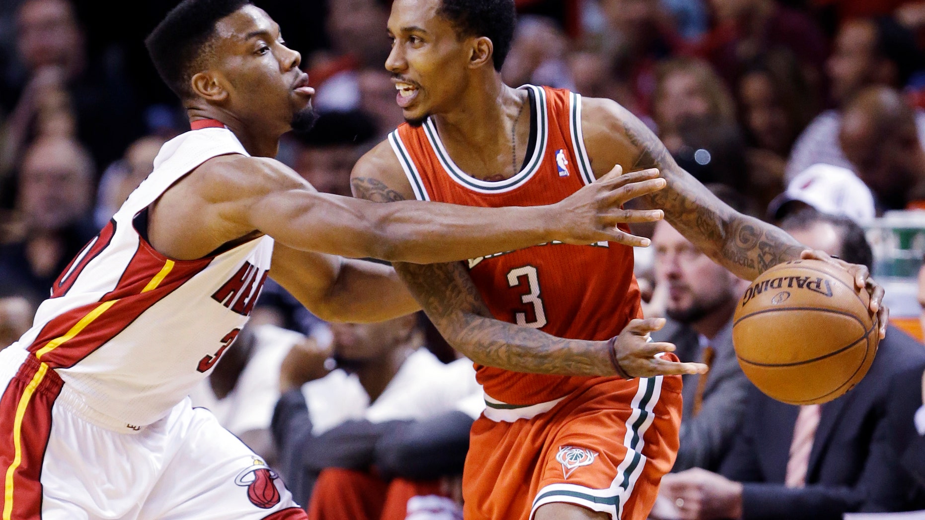 Miami Heat guard Norris Cole, left, defends against Milwaukee Bucks guard Brandon Jennings during the first half of an NBA basketball game, Tuesday, April 9, 2013, in Miami. (AP Photo/Wilfredo Lee)