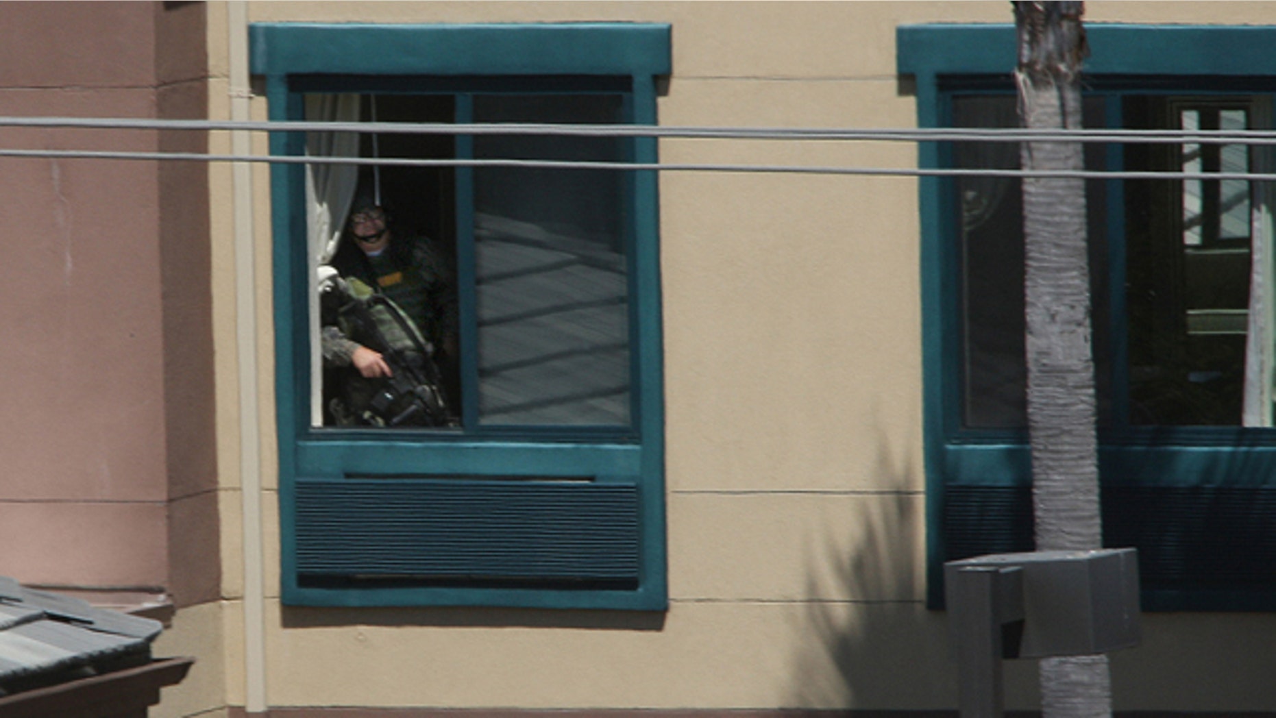 A police officer looks towards the room where an armed man had barricaded himself at an Extended Stay Hotel.