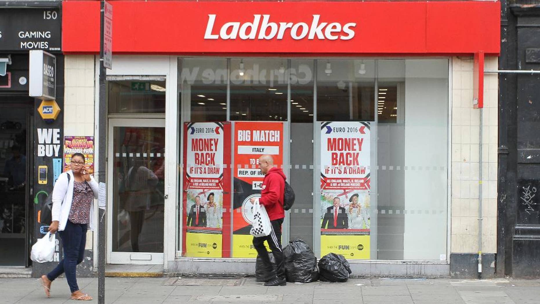 People walk past a Ladbrokes betting shop in London, Wednesday June 22, 2016. Thursday’s referendum on whether to leave the European Union, which could have lasting consequences for the country and Europe, is due to break the record as the most bet-upon political event in Britain’s history. (AP Photo/Leonora Beck)