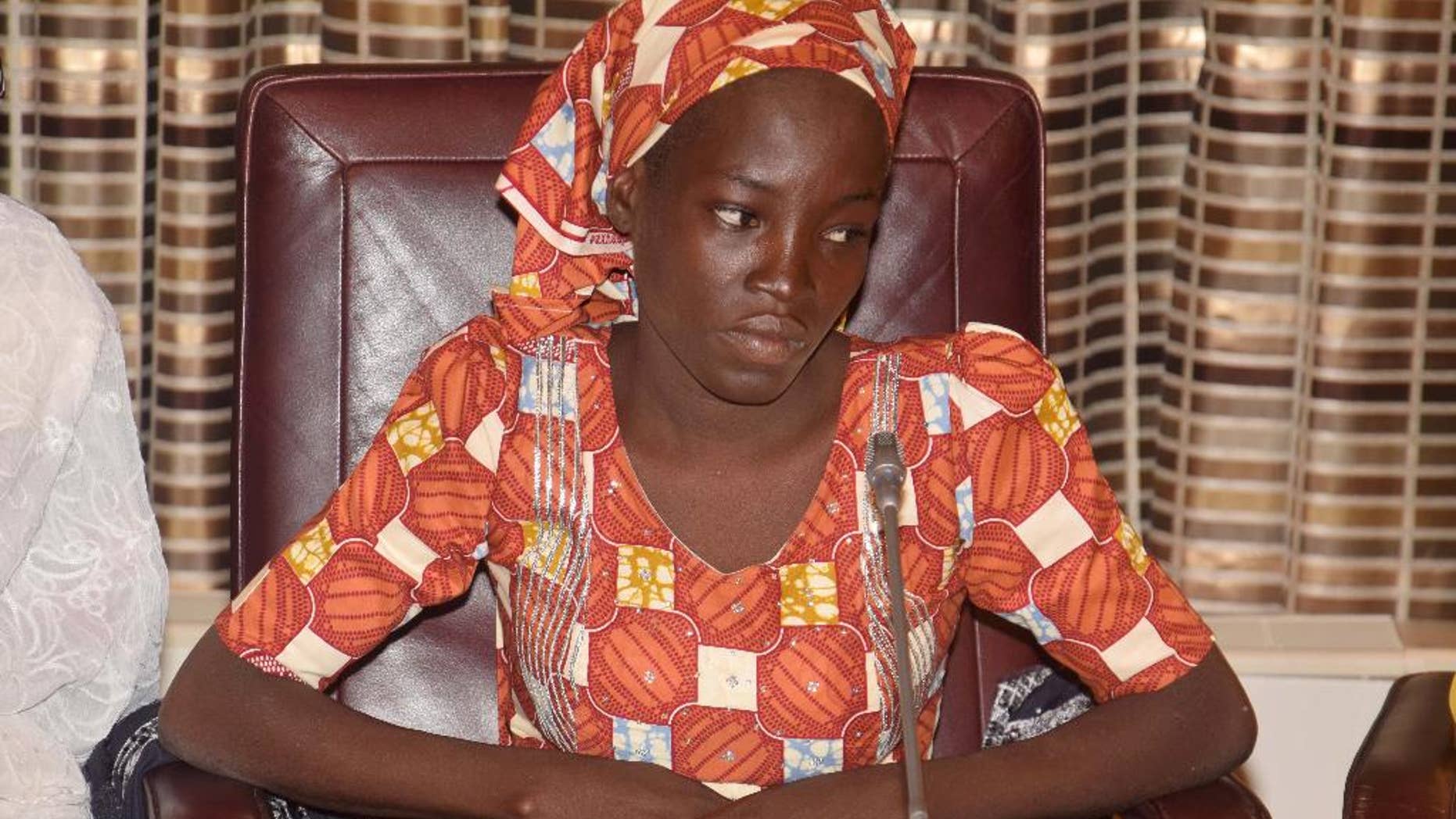 FILE- In this Thursday, May. 19, 2016 file photo, Amina Ali, the rescue Chibok school girl, sits during a meeting with Nigeria's President Muhammadu Buhari at the Presidential palace in Abuja, Nigeria. Nigeria's Bring Back Our Girls movement demanded Wednesday, June. 22, 2016 that the government provide news of the only one of 219 kidnapped schoolgirls to escape the clutches of the Boko Haram extremist group. (AP Photo/Azeez Akunleyan, File)