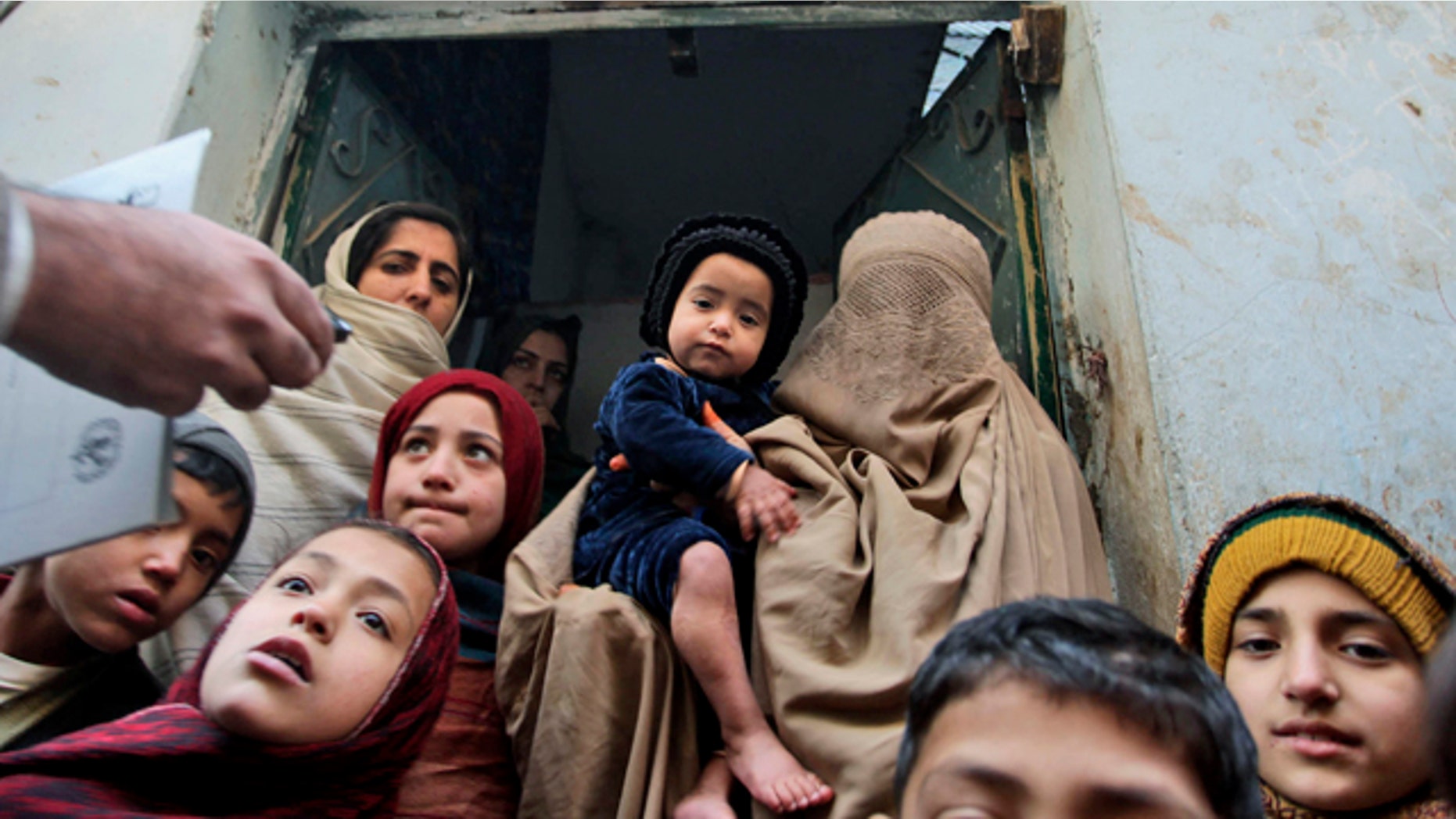 In this Dec. 28, 2010 file photo, a Pakistani health worker, left, visits families to inform them on polio in Peshawar, Pakistan. In his 2009 speech to the Muslim world, President Obama announced a new effort to eradicate polio, which persists in three Muslim countries.