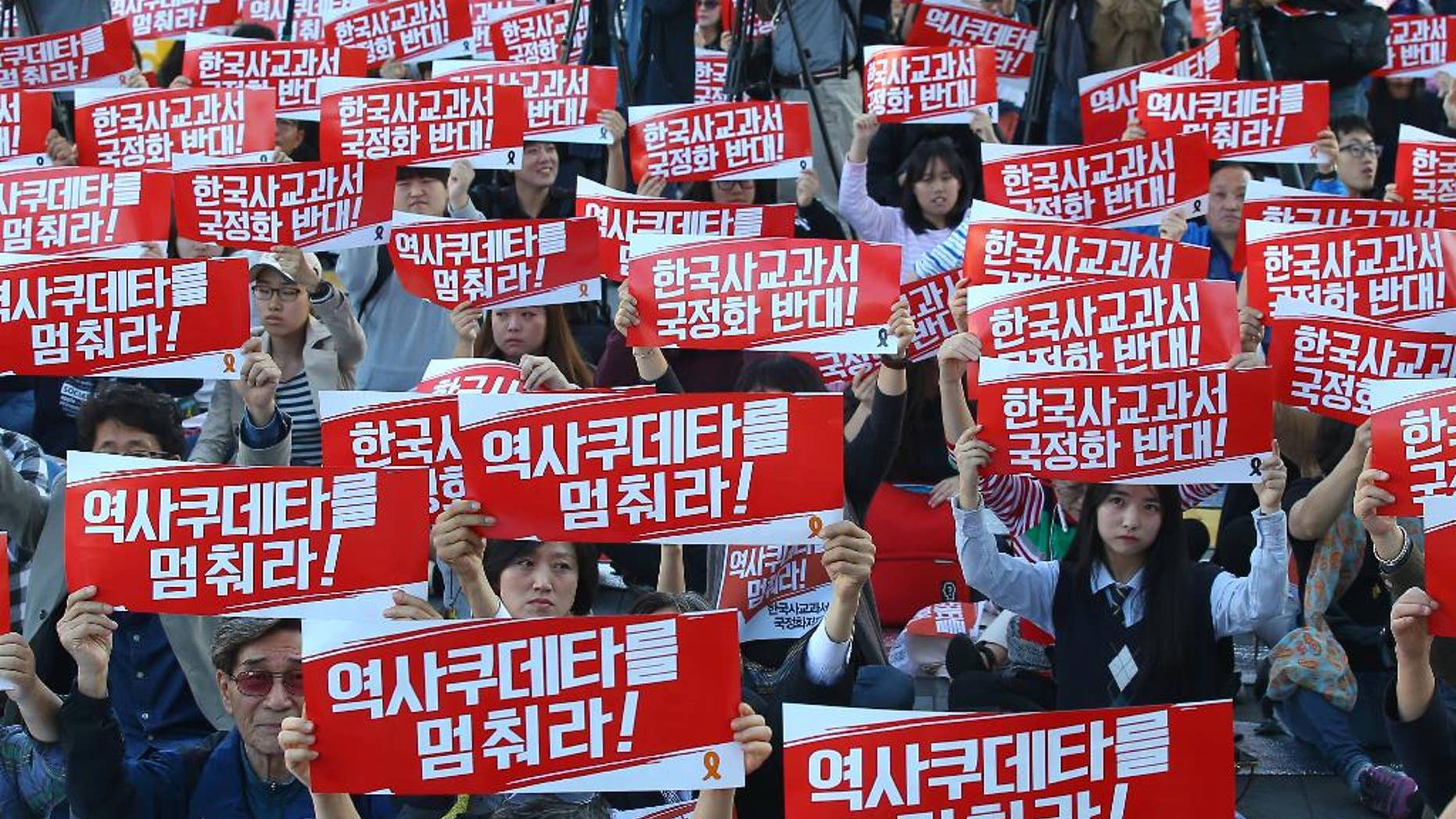 Protesters shout slogans as they hold banners during a rally to opposite the government plan for the state issued history textbooks in Seoul, South Korea, Saturday, Oct. 17, 2015. Hundreds of South Korean scholars have declared they are boycotting the writing of state-issued history textbooks out of concern that that they will teach distorted views on the country's recent past. The banners read: "Oppose, the state issued history textbooks." (Kim Do-hun/Yonhap via AP) KOREA OUT