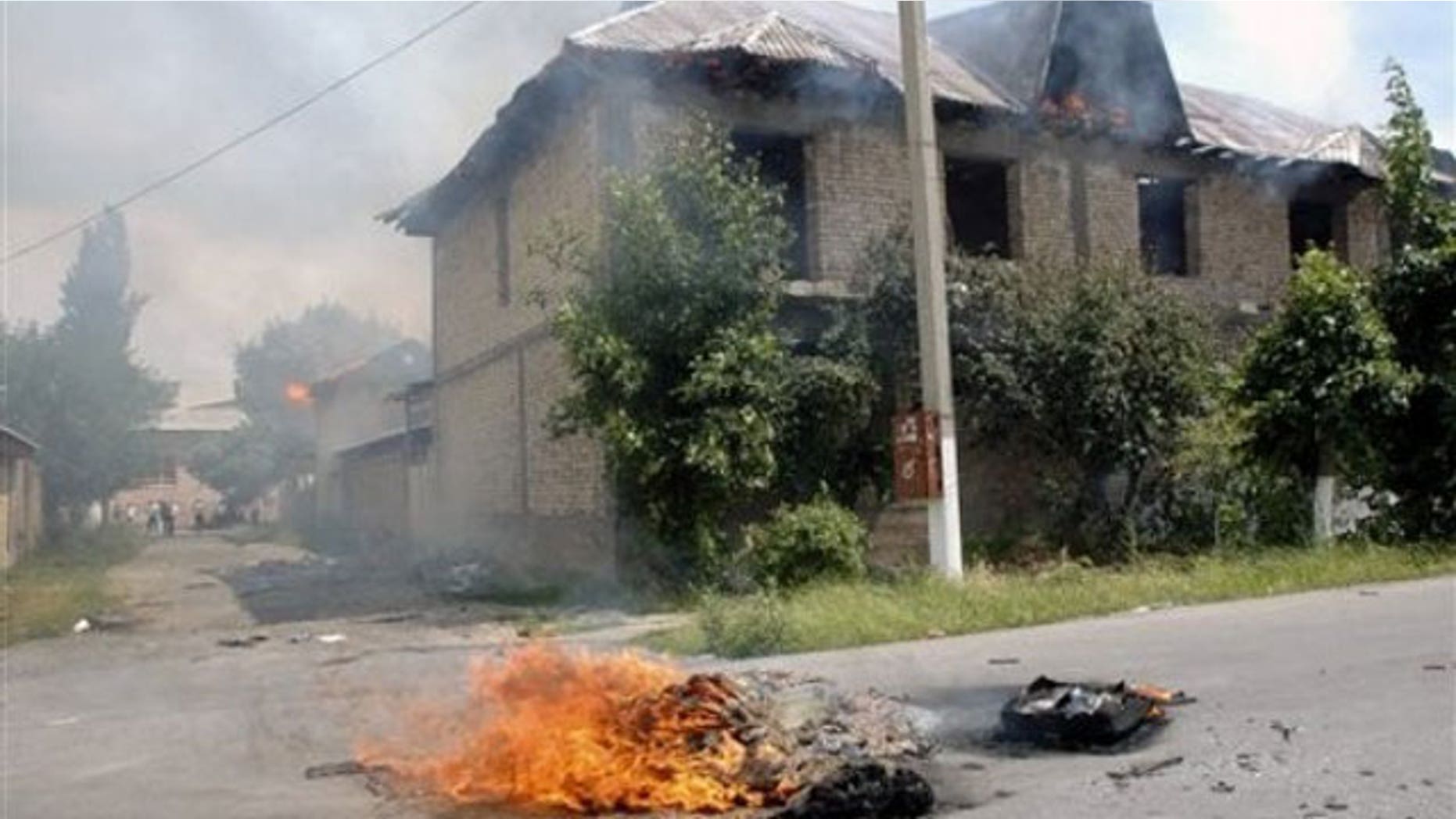 June 13: Ethnic Uzbeks residences burn after being torched by Kyrgyz men, in Jalal-Abad, Kyrgyzstan.