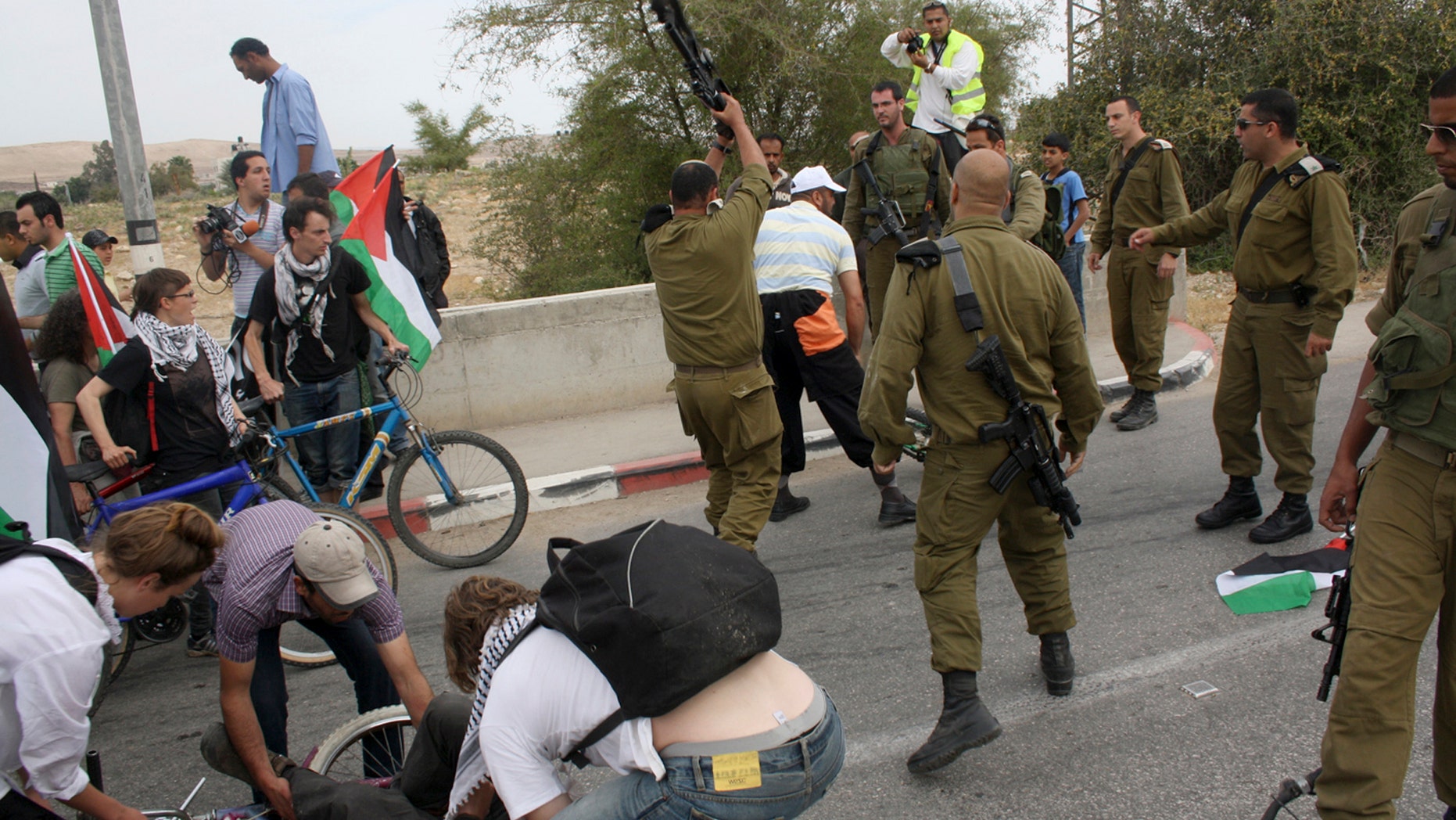 April 14: Israeli army Lt. Col. Shalom Eisner, seen from back center, hits an unidentified activist with an M-16 rifle in the Jordan Valley.