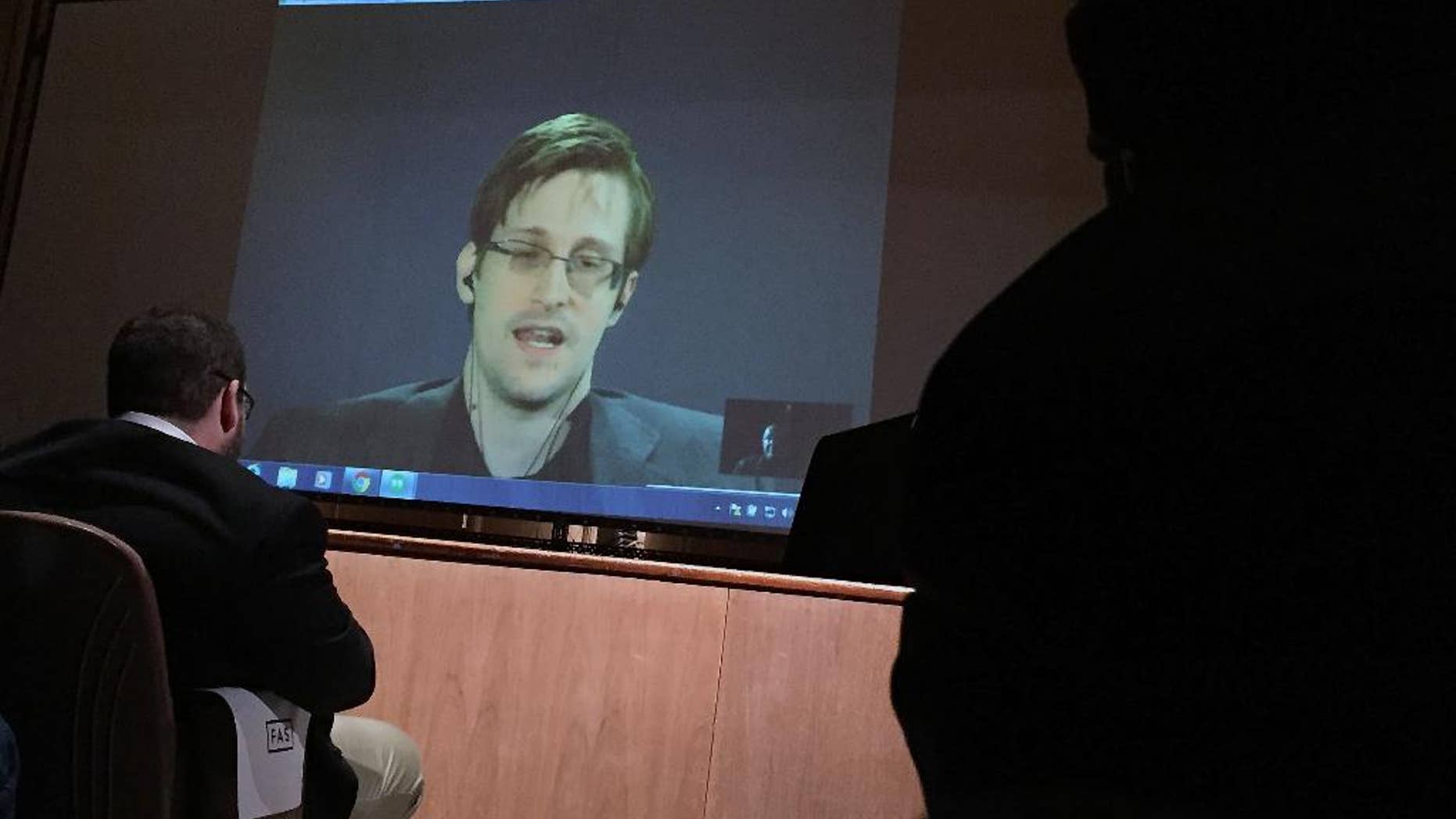 In this photo taken Feb. 17, 2016, former National Security Agency contractor Edward Snowden, center speaks via video conference to people in the Johns Hopkins University auditorium in Baltimore. The Senate on Wednesday, June 22, 2016, blocked an expansion of the government's power to investigate suspected terrorists, a victory for civil libertarians and privacy advocates emboldened after a National Security Agency contractor's revelations forced changes in how the communications of Americans are monitored. (AP Photo/Juliet Linderman)