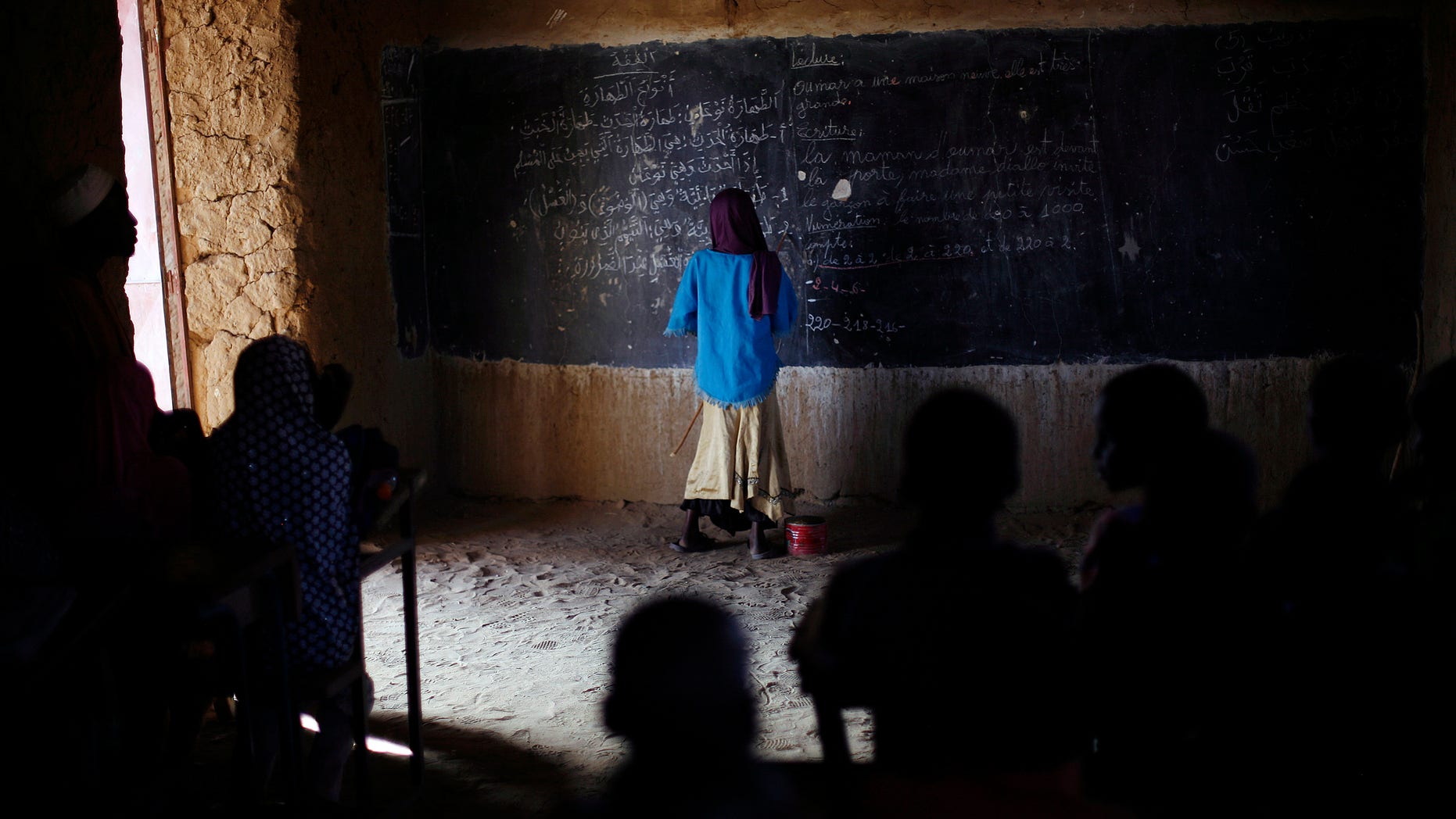 Feb. 18, 2013: A Malian schoolgirl stands at the blackboard as schools reopen in Gao, northern Mali.
