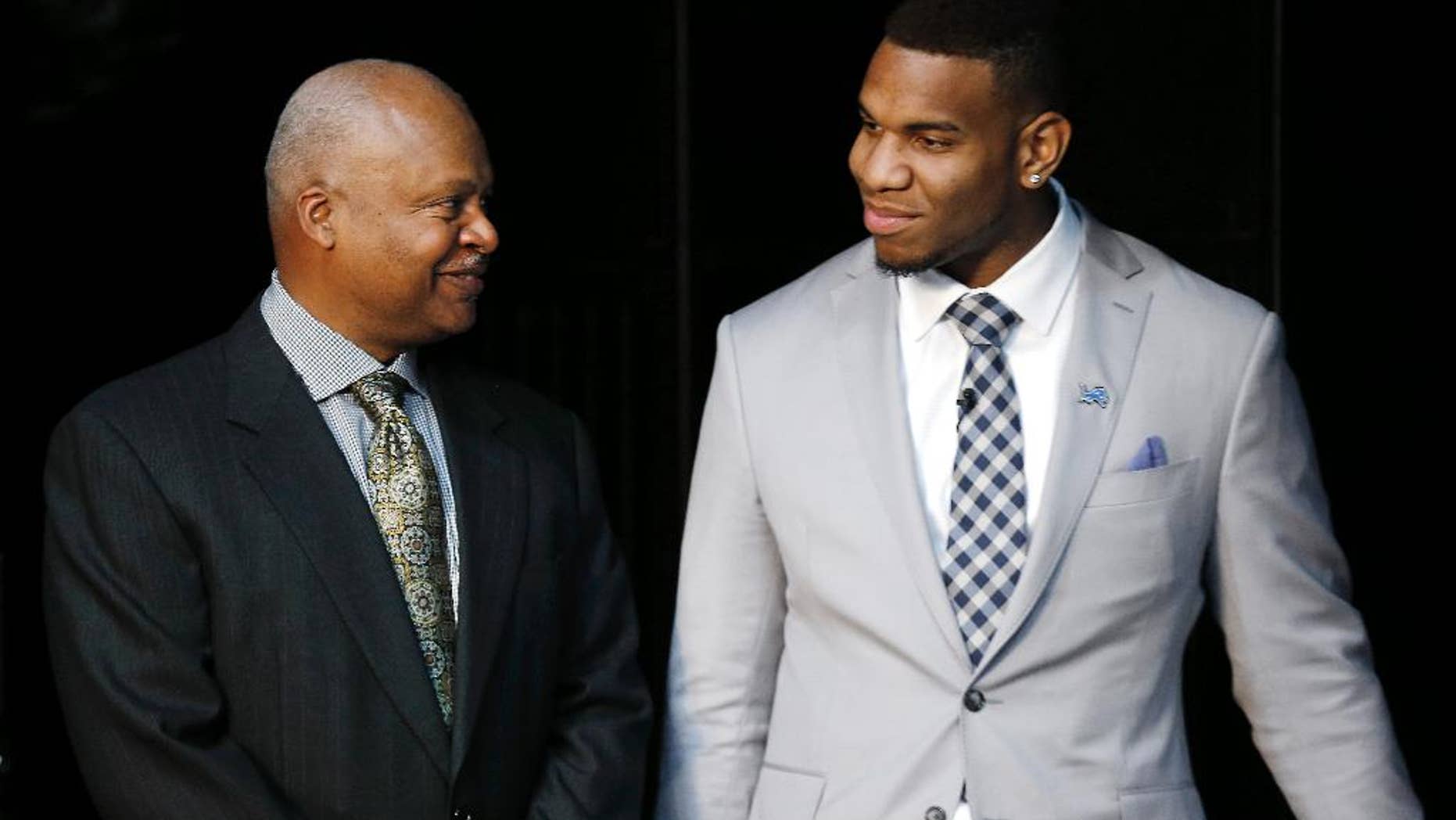 Detroit Lions head coach Jim Caldwell, left, talks to NFL football first round draft choice, 10th overall, North Carolina tight end Eric Ebron before a news conference in Allen Park, Mich., Friday, May 9, 2014. (AP Photo/Paul Sancya)